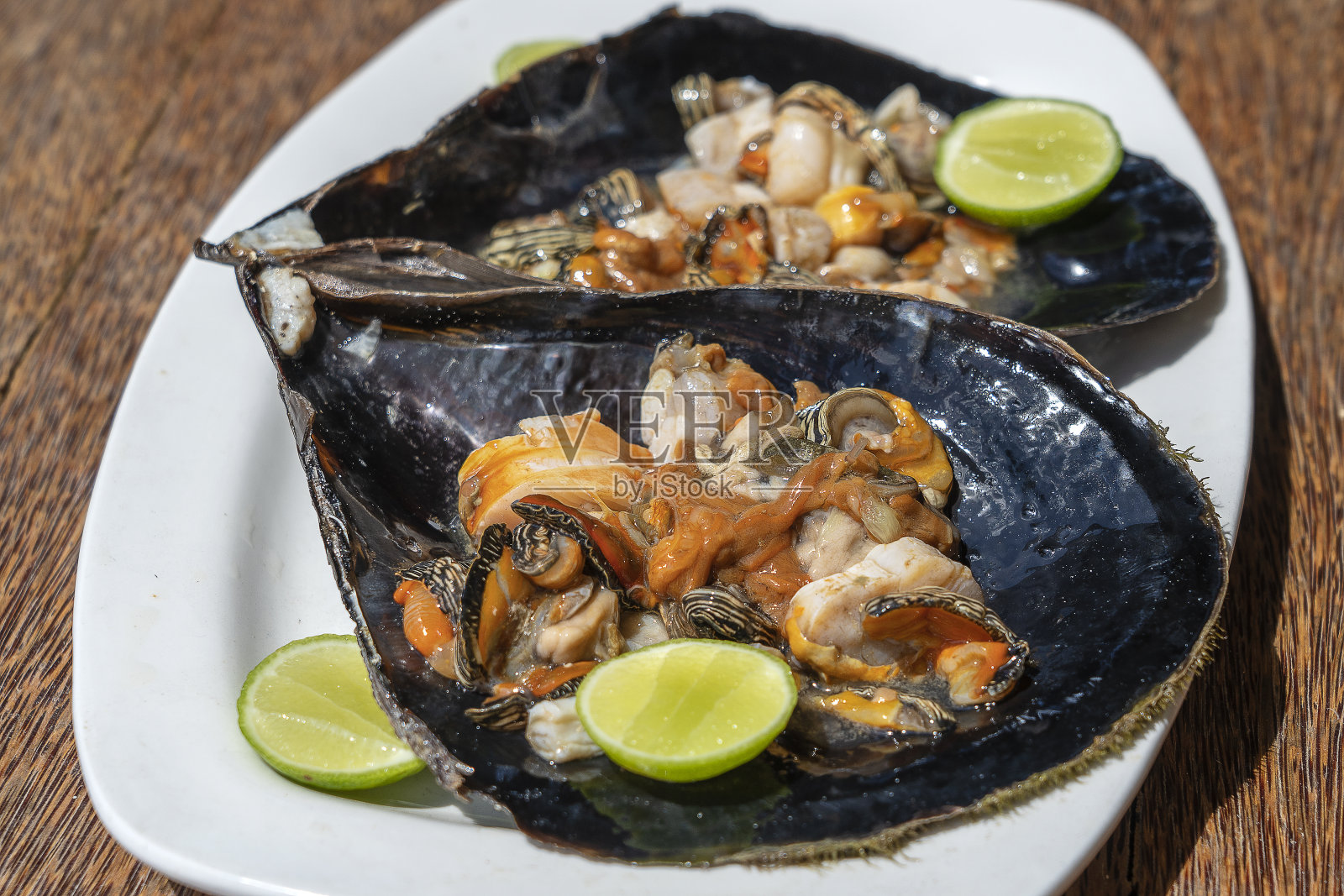 东非坦桑尼亚桑给巴尔岛上的一家当地餐馆里，盛在大贝壳里的生蛤蜊肉照片摄影图片