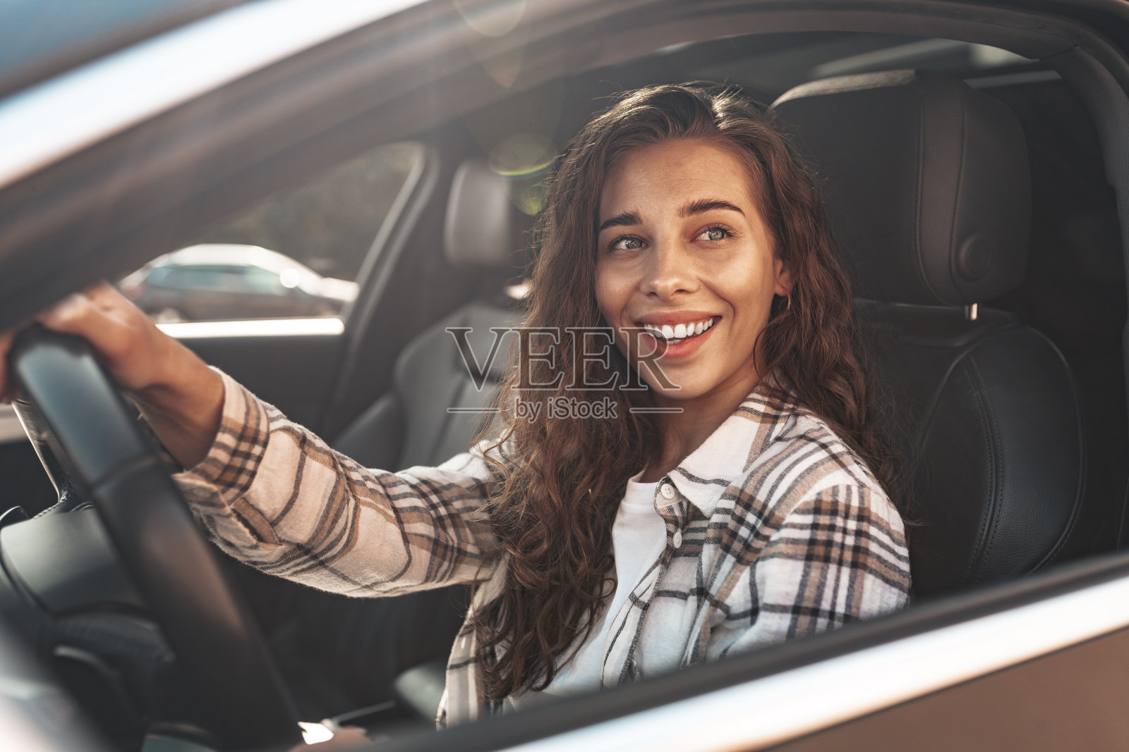 一个美丽的微笑的女人在车里看着窗外的画像照片摄影图片