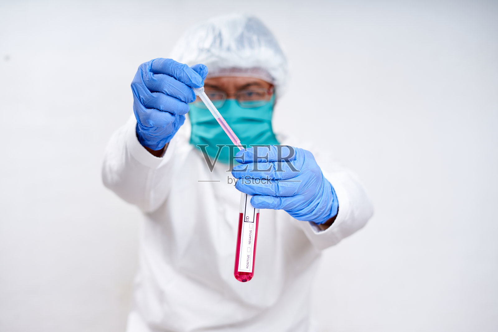 戴着口罩和手套的男性科学家手持DNA试管进行科学测试照片摄影图片