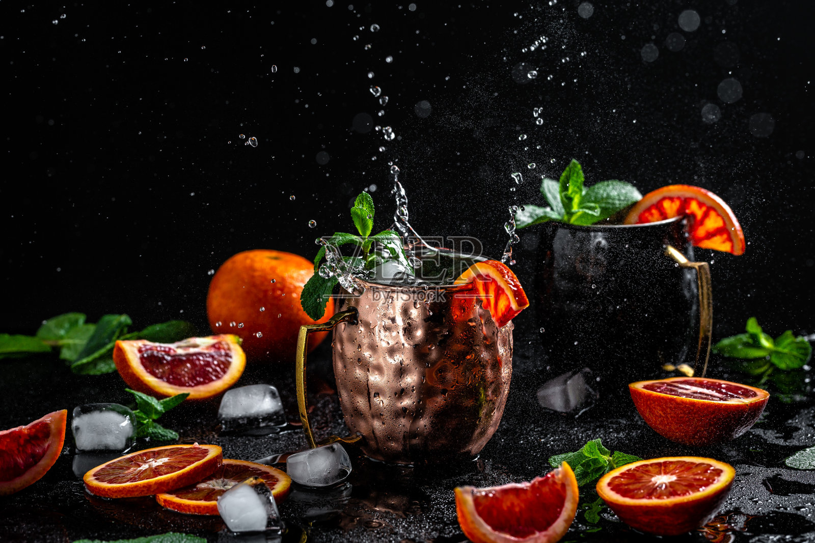 莫斯科骡子鸡尾酒溅在铜杯与血橙，姜汁啤酒，伏特加和薄荷，横幅，菜单，食谱，文本的地方照片摄影图片