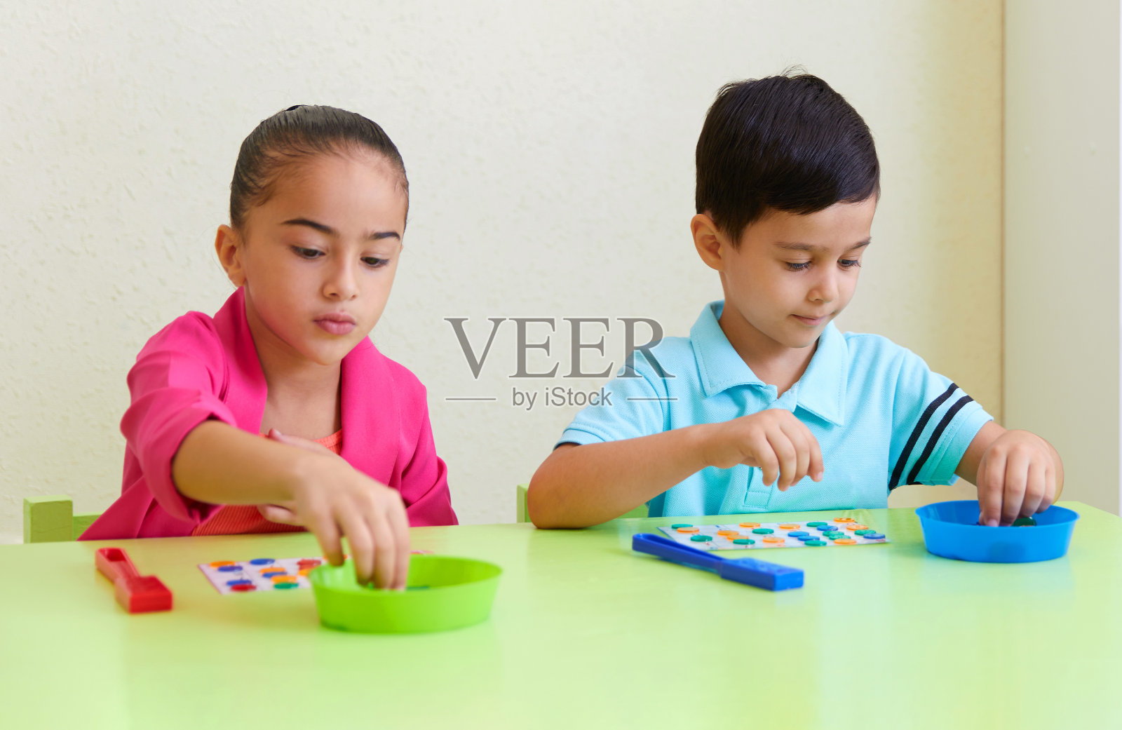 学龄前儿童在书桌上玩拼图游戏照片摄影图片