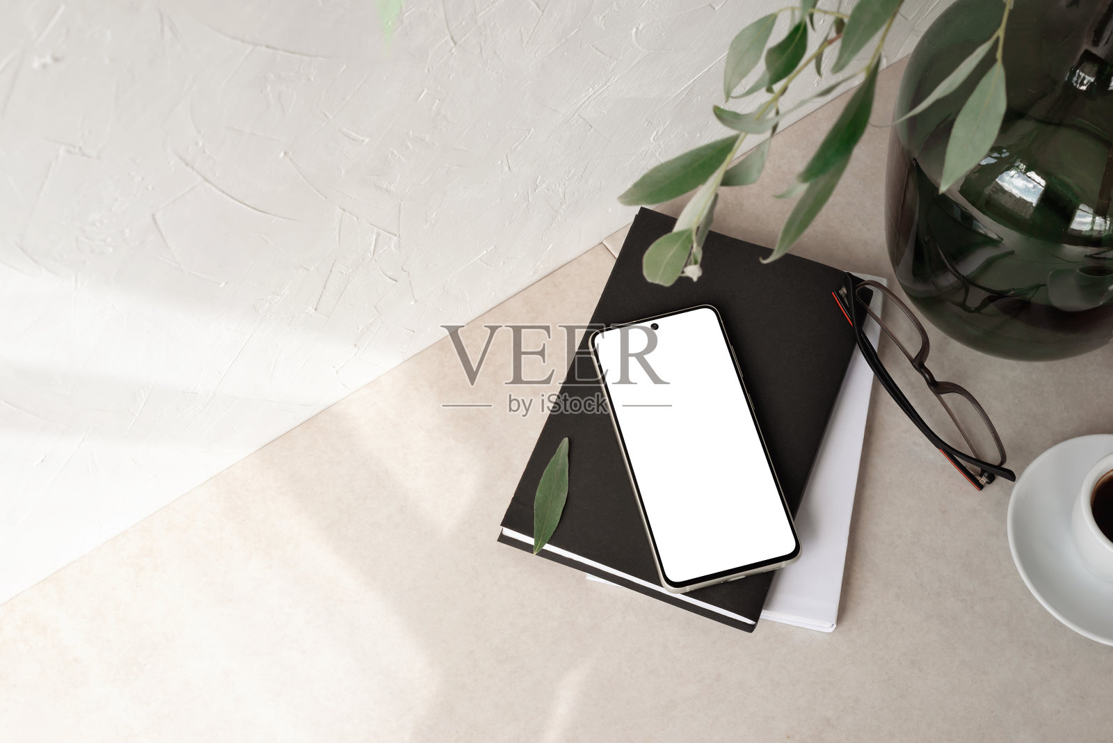 手机配空屏模型，笔记本，眼镜，花瓶配枝叶，空中性米色背景配审美阳光阴影，极简商业品牌，社交媒体博客模板照片摄影图片