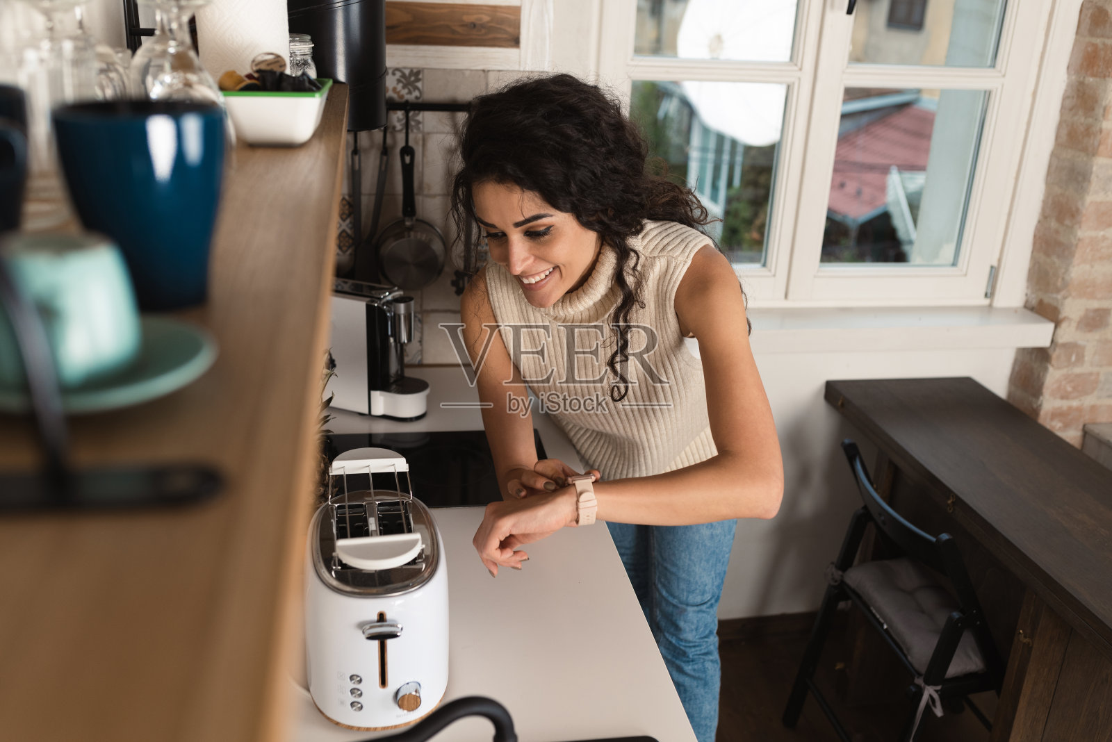 快乐的女人在家里使用智能手表照片摄影图片