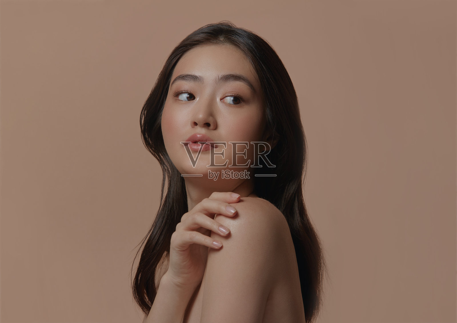 美丽的年轻亚洲种族妇女的肖像与清洁健康的皮肤在米色孤立的背景。照片摄影图片