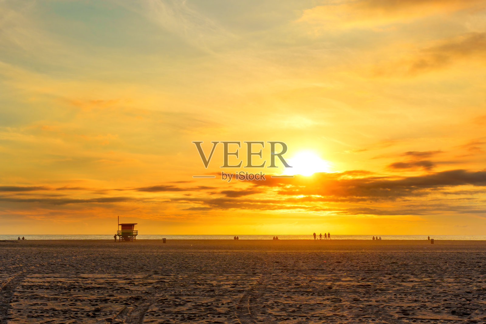 壮观的日落在威尼斯海滩:高耸的太阳和快乐的海滩游客照片摄影图片