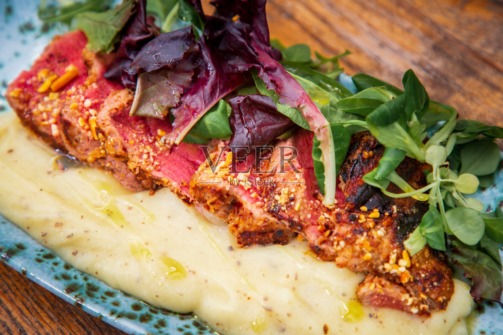 多汁的牛排片，半熟，配以香草调味的土豆泥照片摄影图片