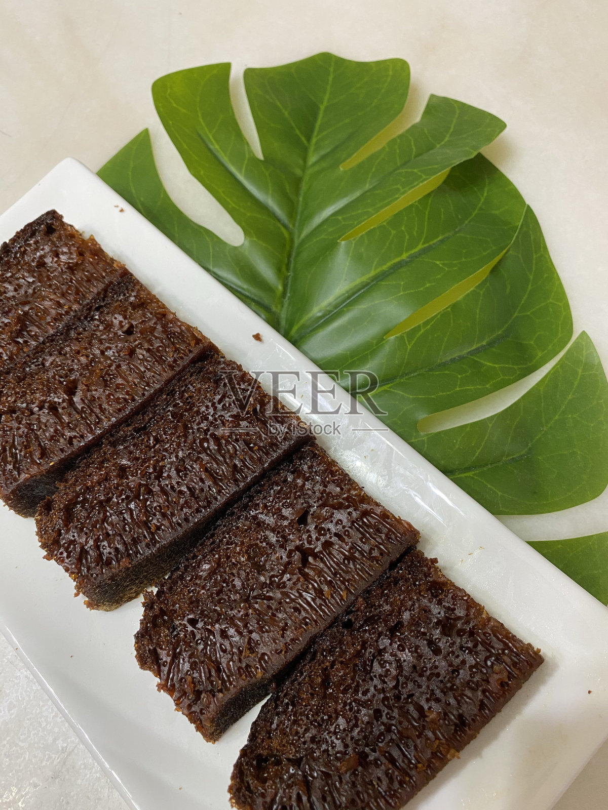 蜂窝湿焦糖蛋糕也被称为kek sarang semut或kek gula hangus在马来西亚的深色背景。照片摄影图片