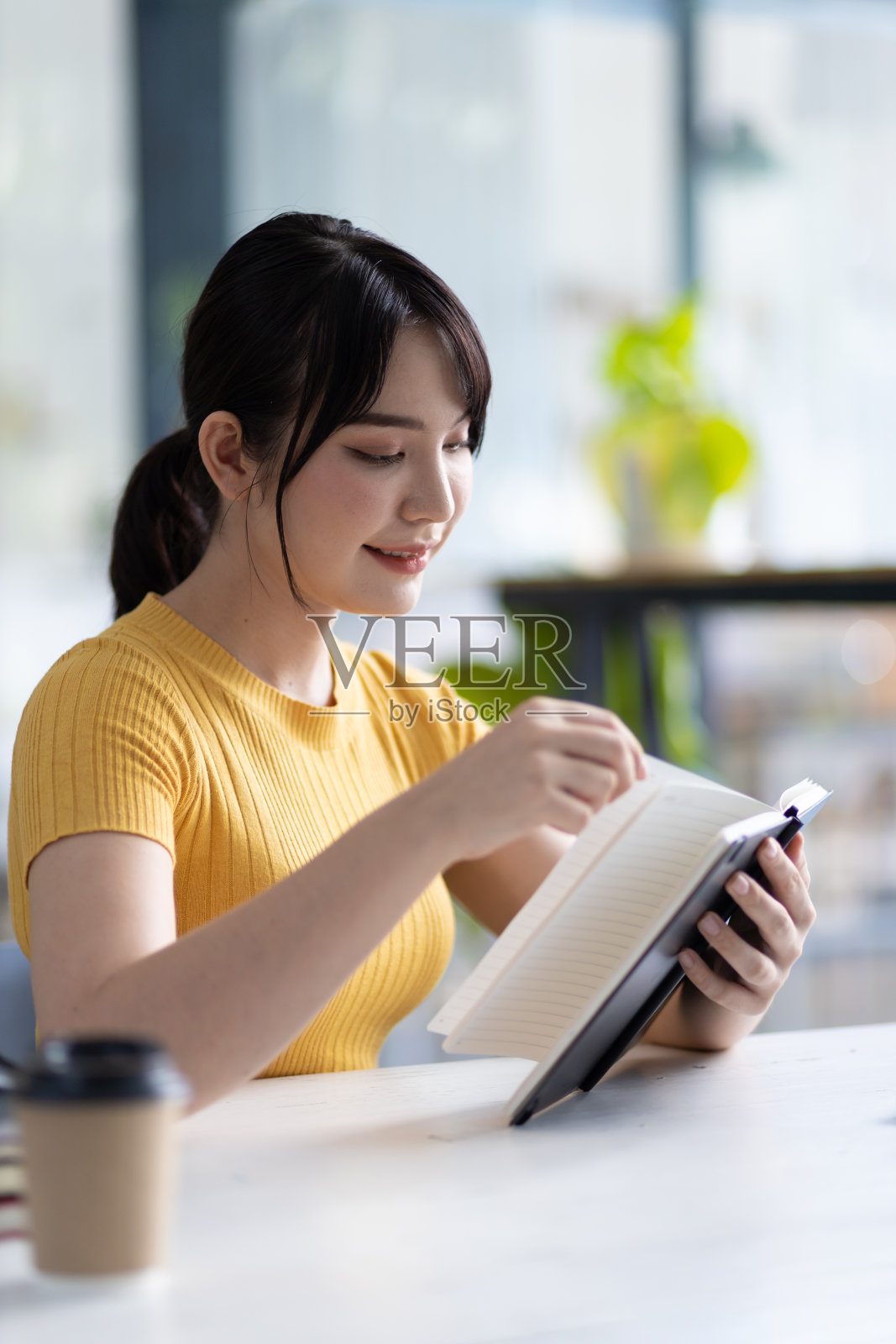 一个年轻的亚洲女人在图书馆看书的肖像。照片摄影图片