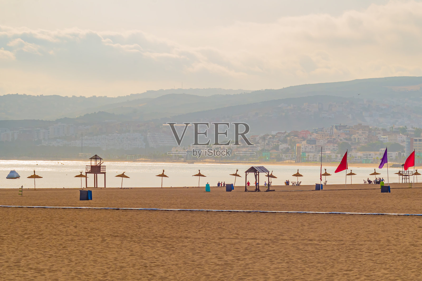 在旅游旺季的夏季阳光明媚的日子里，清晨的海滩景观仍然很少有海滩游客占据他们的位置。暑假、度假的概念照片摄影图片