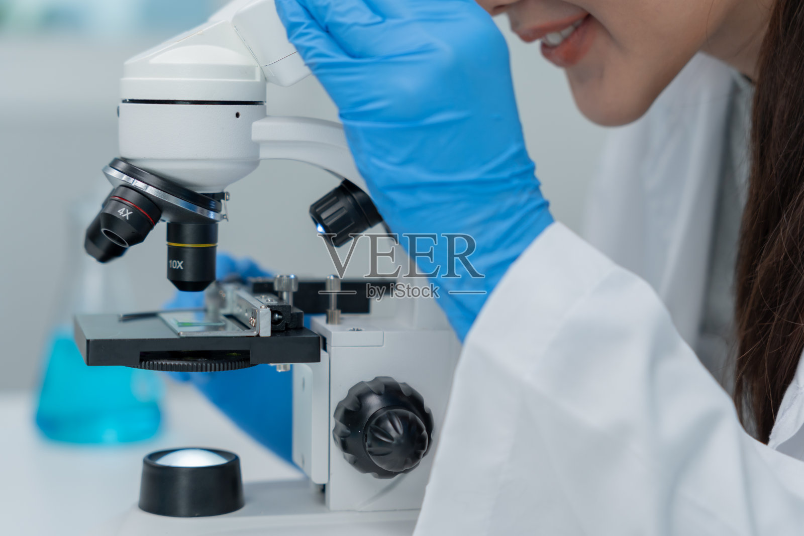 科学家在先进的科学实验室里分析生化样品。医学专业人员用显微镜观察病毒的微生物发育。实验室生物技术研究。照片摄影图片