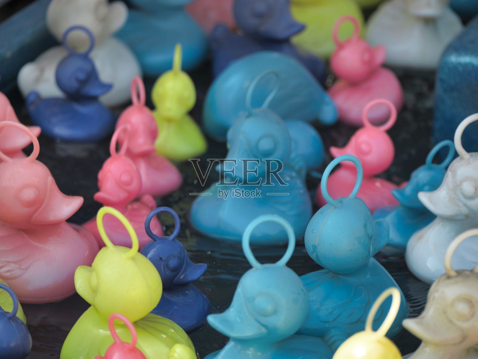 泳池里五颜六色的塑料鸭子玩具的特写照片摄影图片