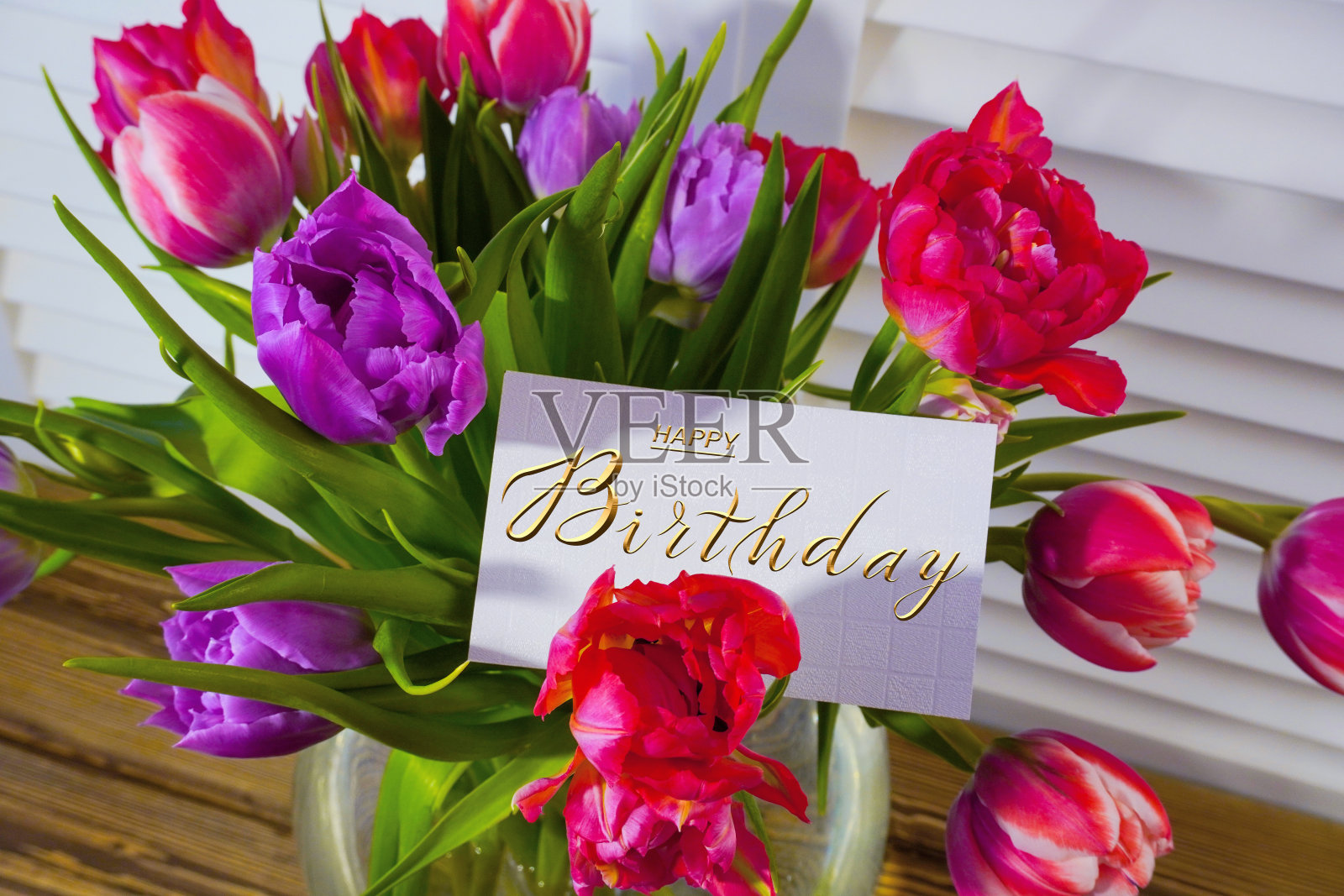 明信片上，网上挂着生日祝福的横幅，上面写着生日快乐的题词，一束鲜花上写着祝贺的字条照片摄影图片