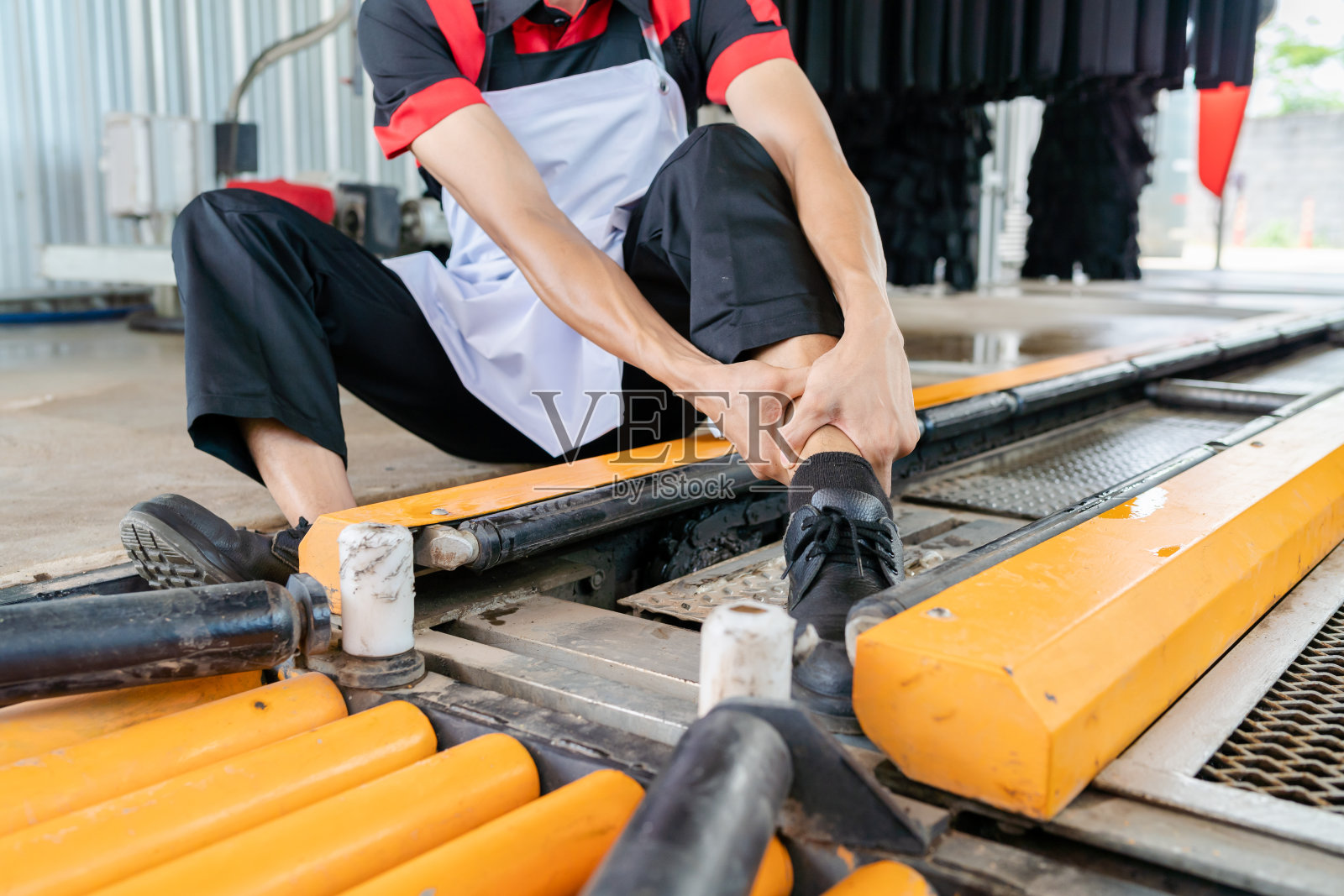 一个亚洲人在上班时穿工作服出了意外。照片摄影图片