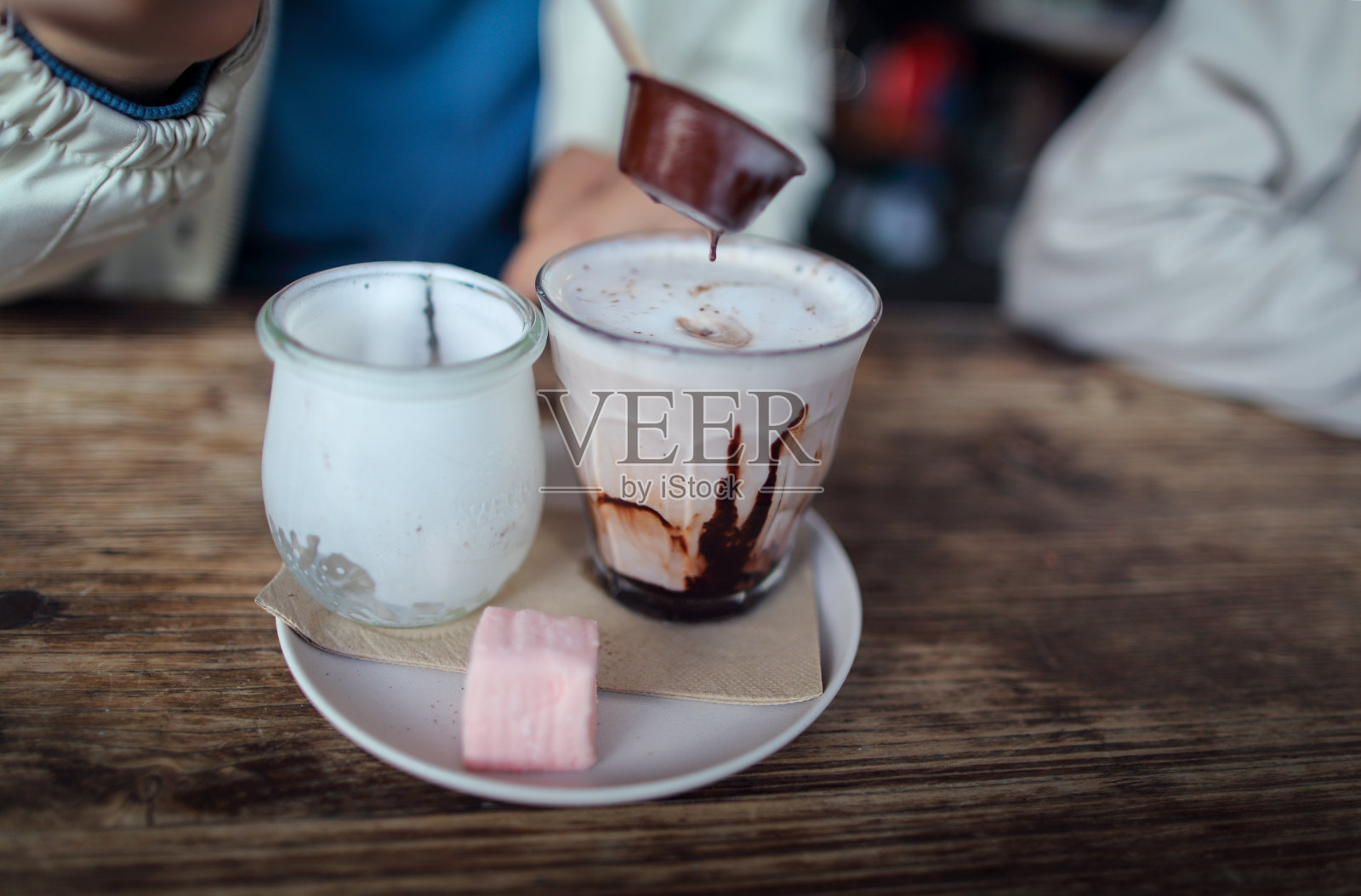 亚洲男孩拿着一块巧克力准备搅拌热巧克力牛奶照片摄影图片