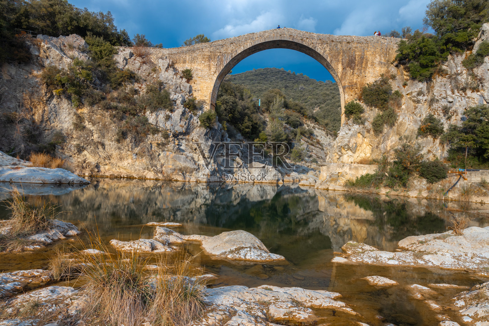 西班牙加泰罗尼亚一座古老的利埃尔卡桥。这座美丽的桥由砂岩板铺设，自14世纪以来一直在使用。照片摄影图片