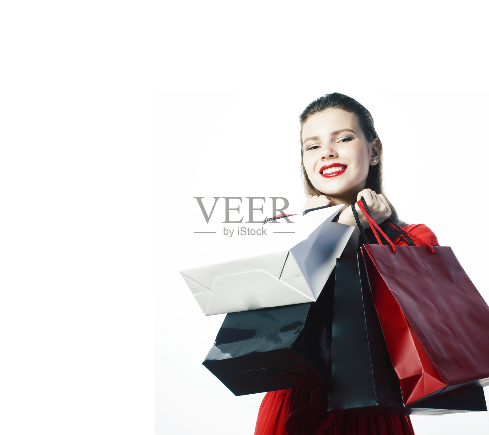 年轻漂亮的金发女子摆出愉快的孤立在白色背景与包圣诞销售红色连衣裙照片摄影图片