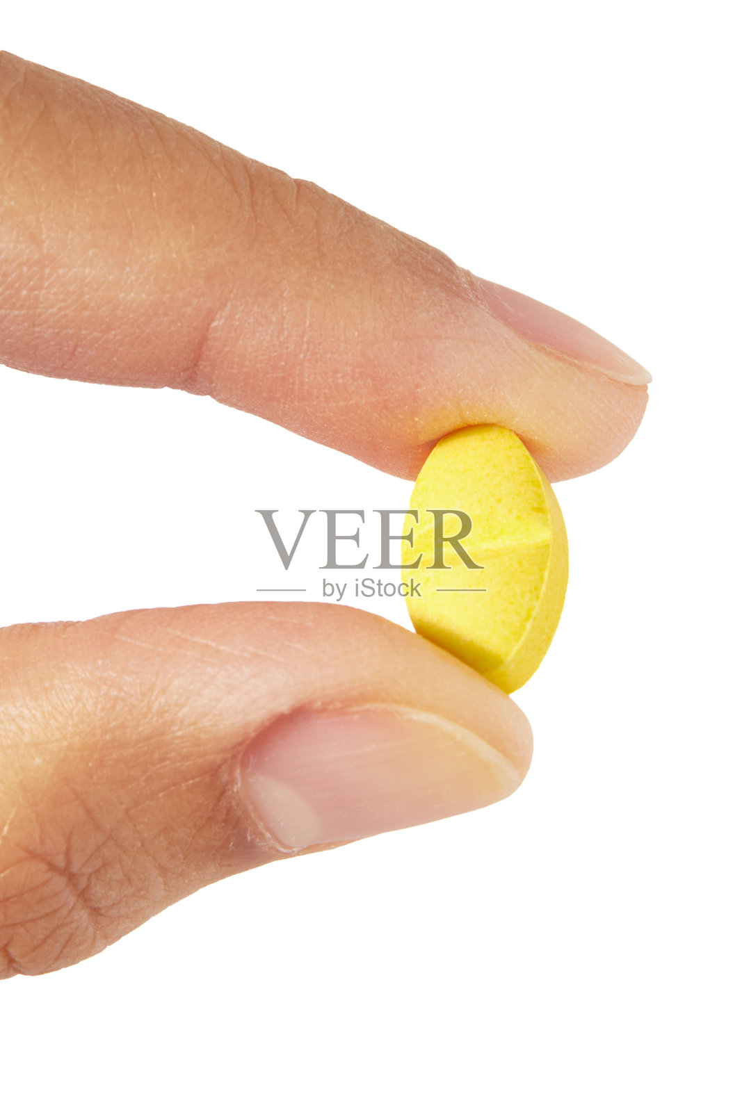 手握椭圆形黄色药丸孤立在白色背景。照片摄影图片