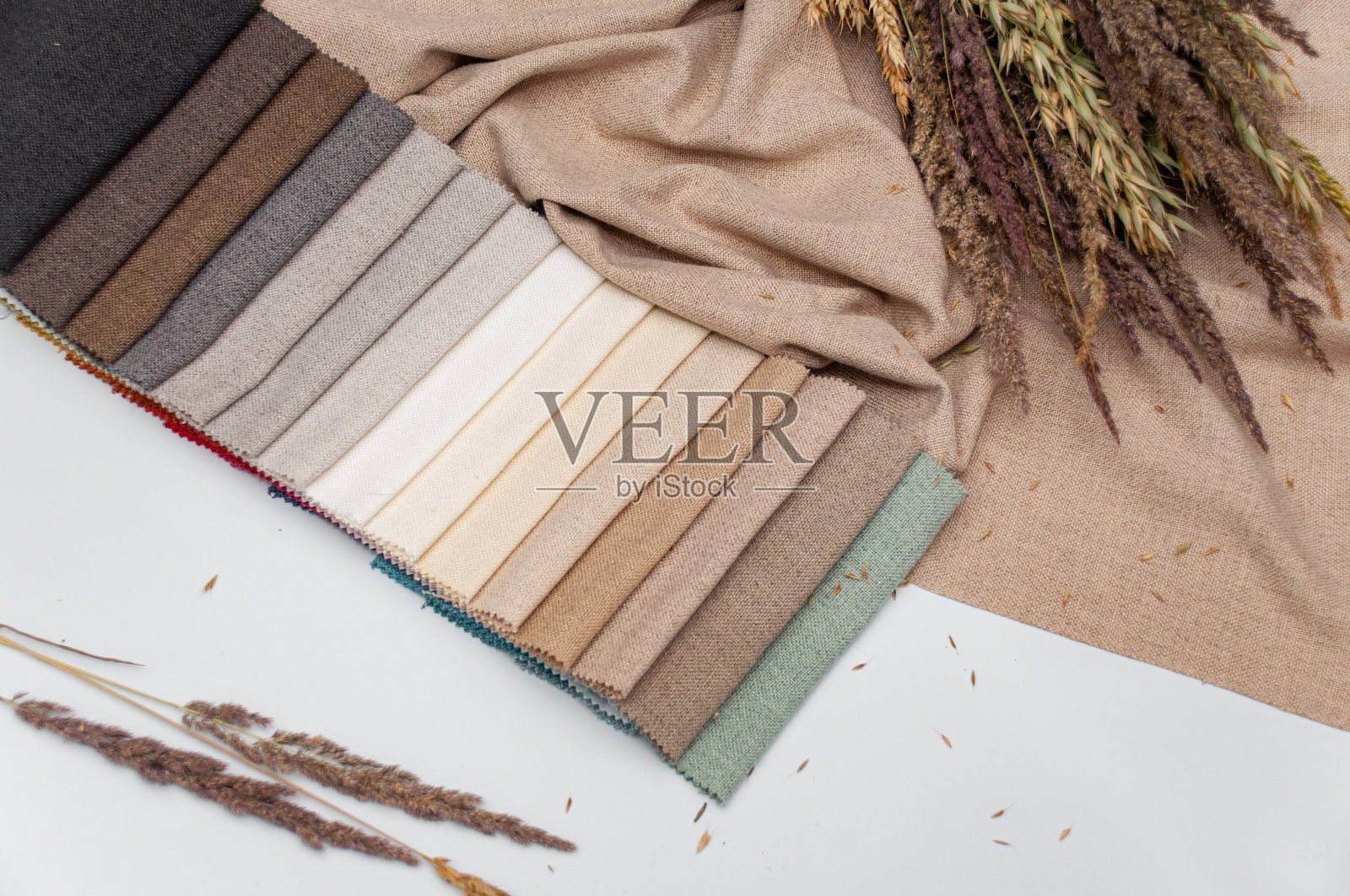 牛奶色、米色和灰色面料的调色板，用于缝制窗帘和家居装饰。照片摄影图片