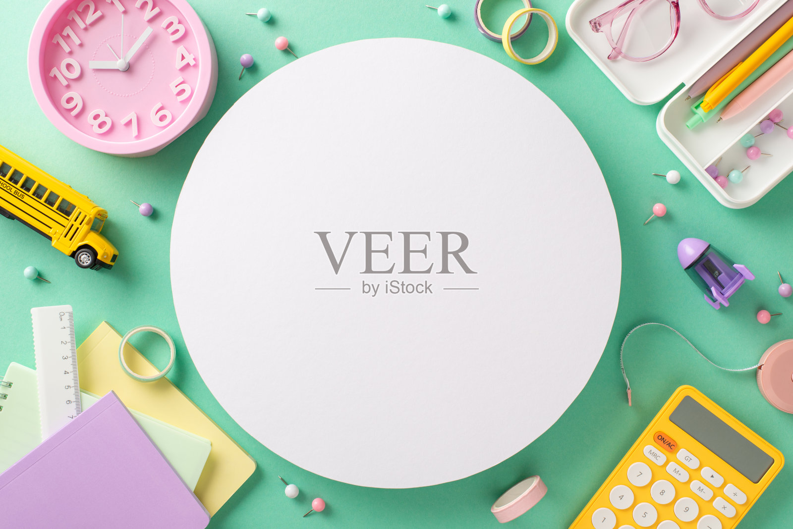 准备好迎接新的学术季节，这张俯视图在柔和的蓝绿色背景上拍摄了充满活力的固定必需品。用文本或广告自定义圆圈内的复制空间照片摄影图片