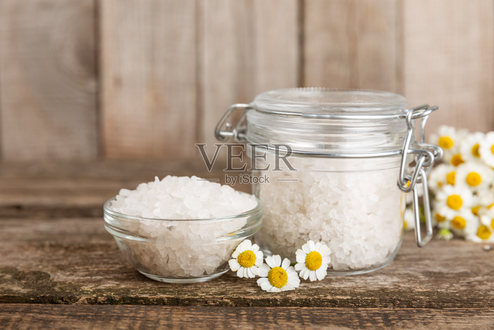 海浴盐与草药洋甘菊提取物纹理背景。盐在玻璃罐里。身体护理化妆品，天然有机产品，草药。美丽的概念。放文字的地方。副本的空间。照片摄影图片
