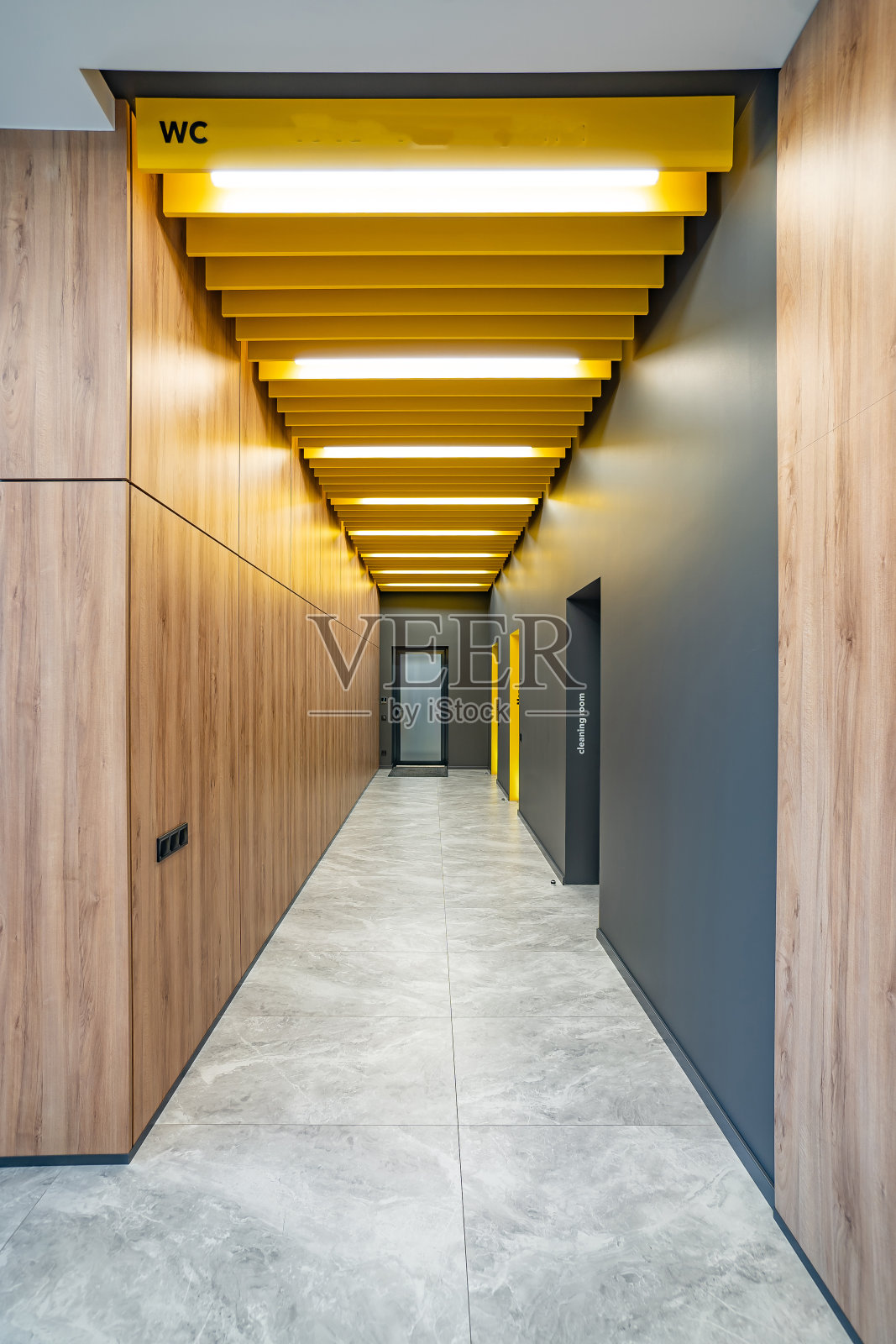 办公楼长走廊的透视图。走廊洗手间的门。办公室门上有厕所标志。工厂洗手间的入口照片摄影图片