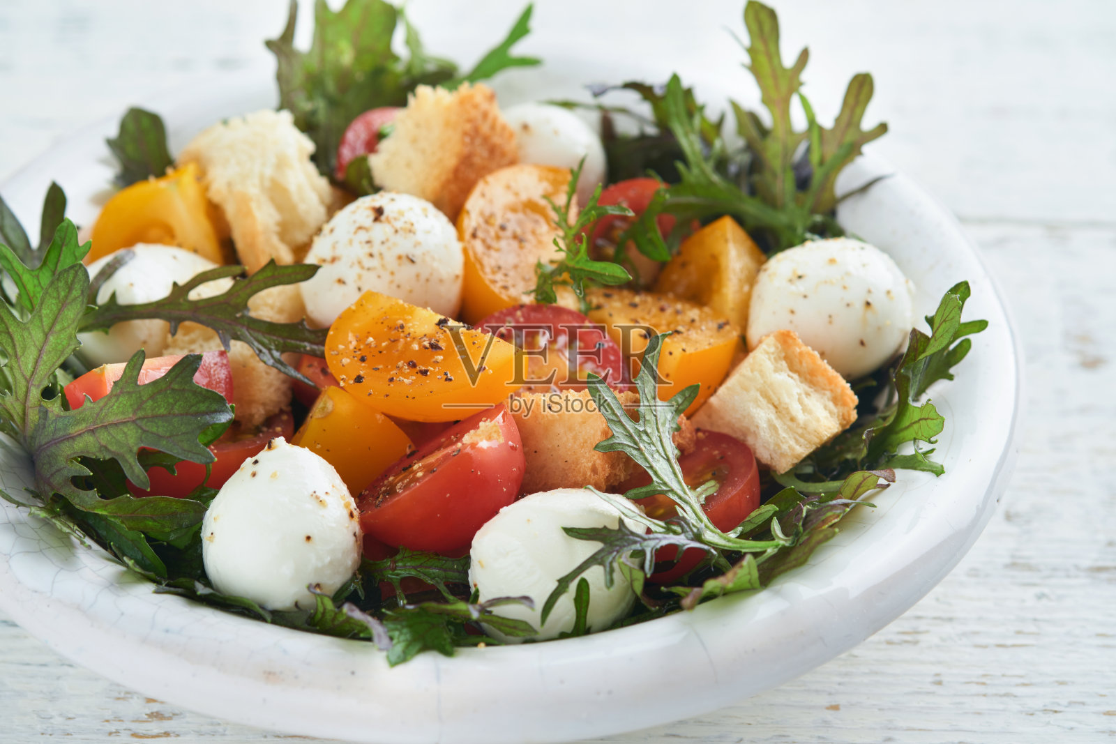 托斯卡纳Panzanella。圣女果沙拉配芝麻菜，罗勒，马苏里拉奶酪和面包饼干。传统的意大利沙拉。地中海健康食品和烹饪。照片摄影图片