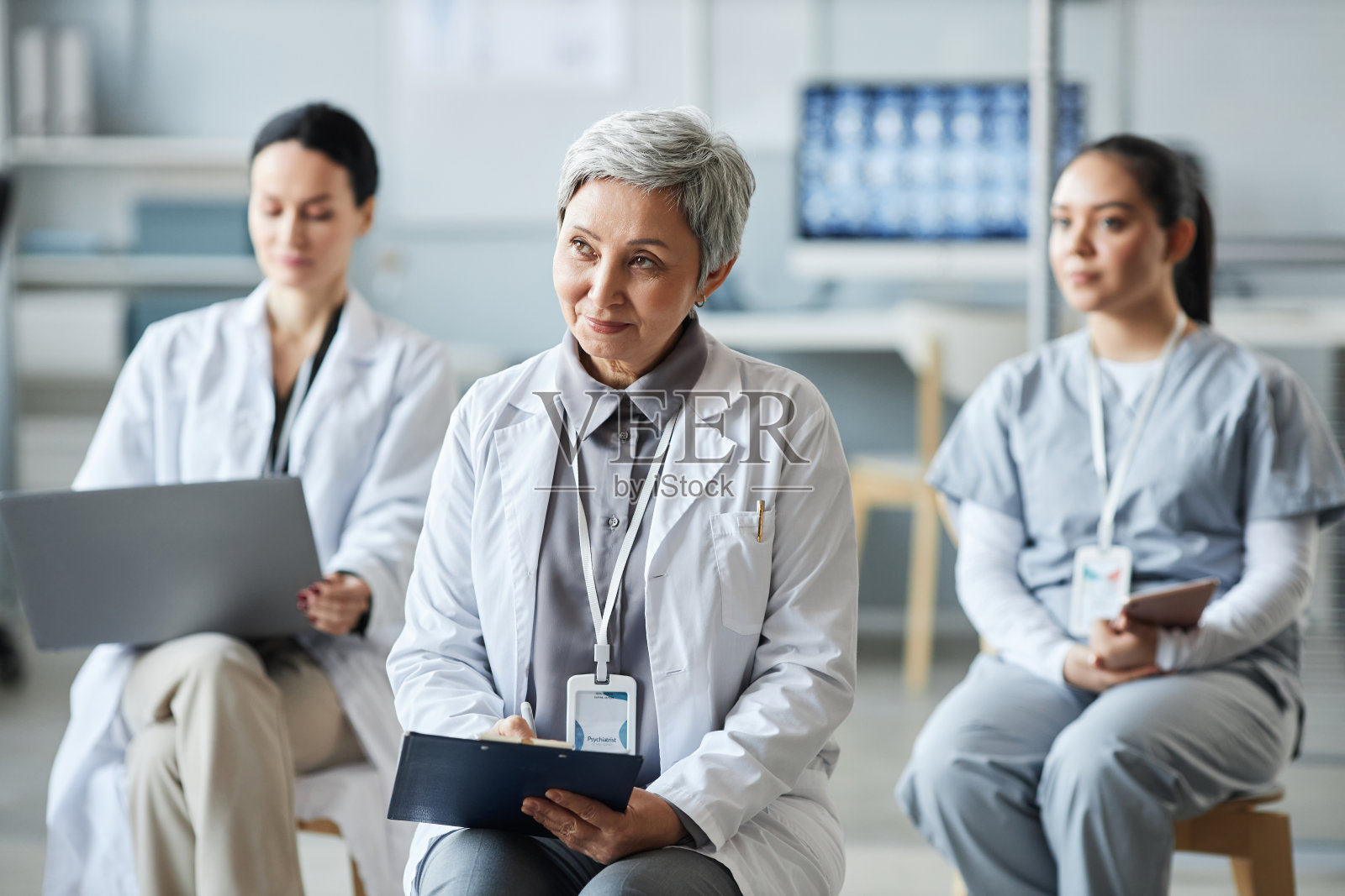 成熟的女性全科医生在研讨会上做笔记照片摄影图片