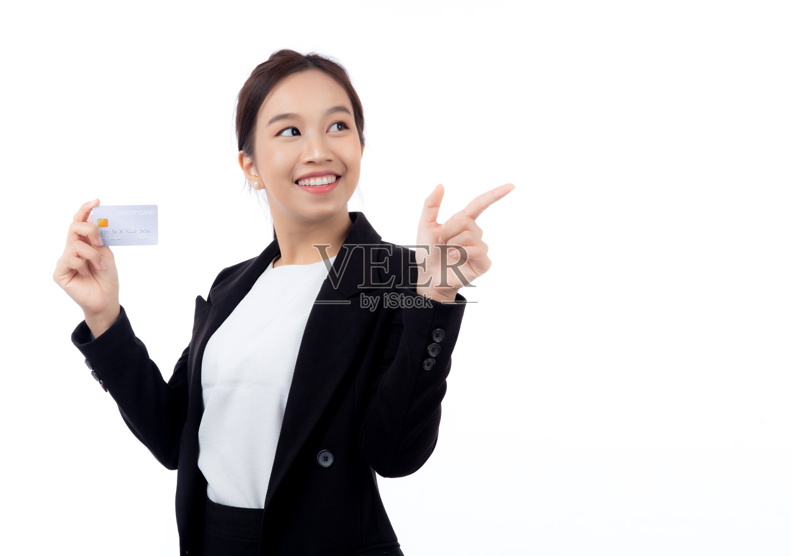 画像中年轻的亚洲女商人手持信用卡或借记卡展示，并以孤立的白色背景呈现女商人网上购物和支付、金融和银行理念。照片摄影图片