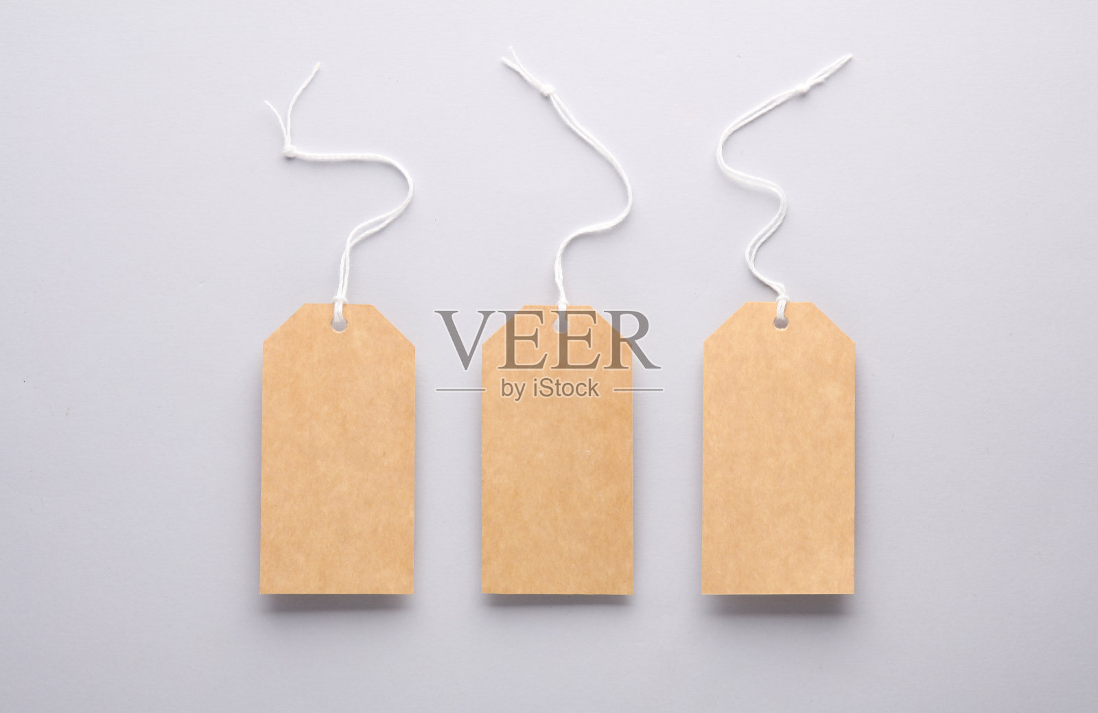 灰色背景上有绳子的空工艺品价格标签。设计模板照片摄影图片