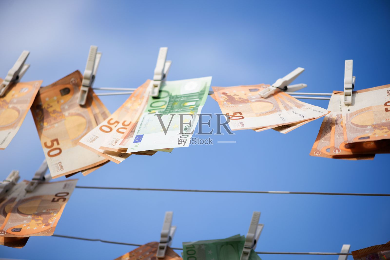 挂在一排衣服上的钞票照片摄影图片