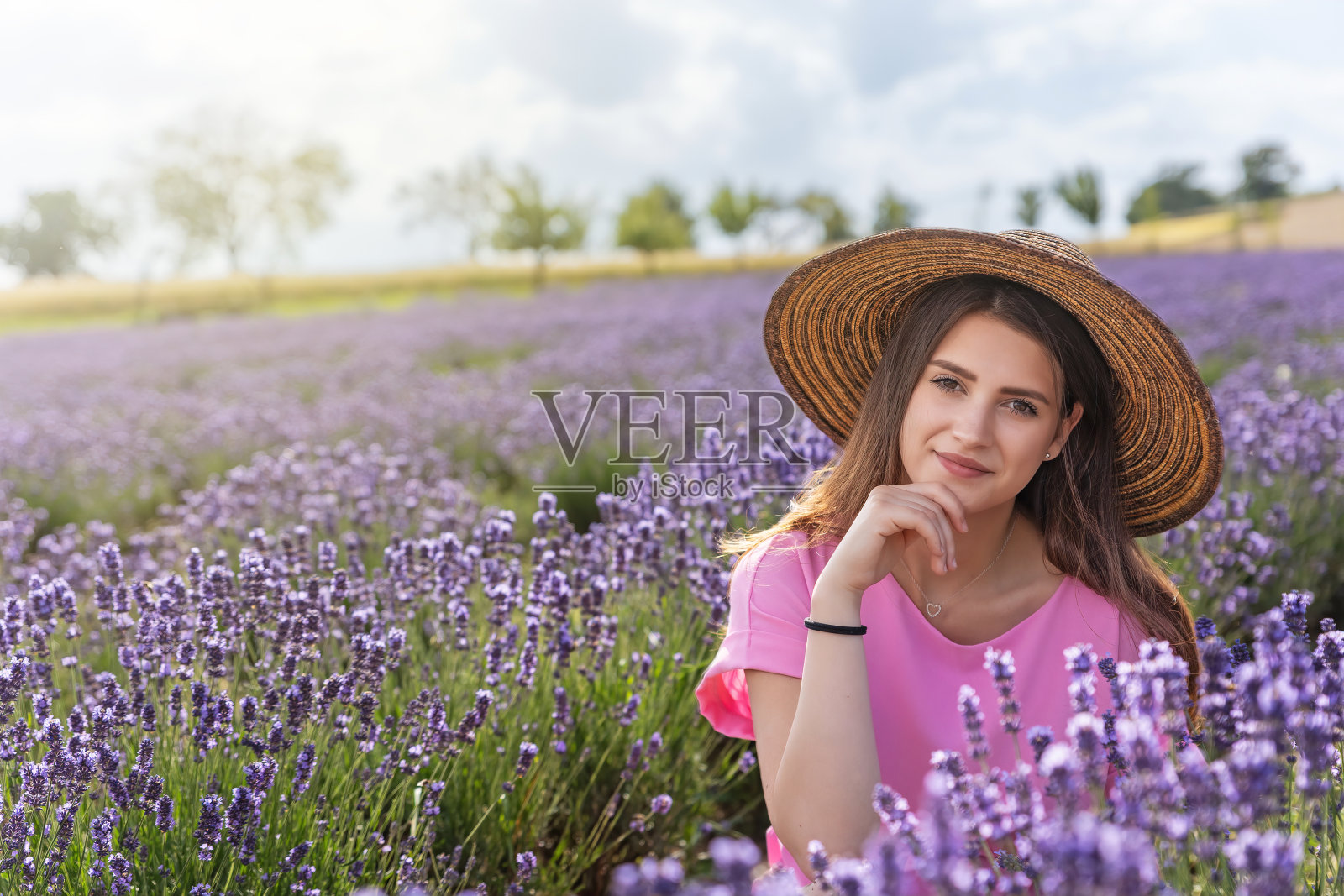 迷人的女孩在薰衣草地里摆姿势。照片摄影图片
