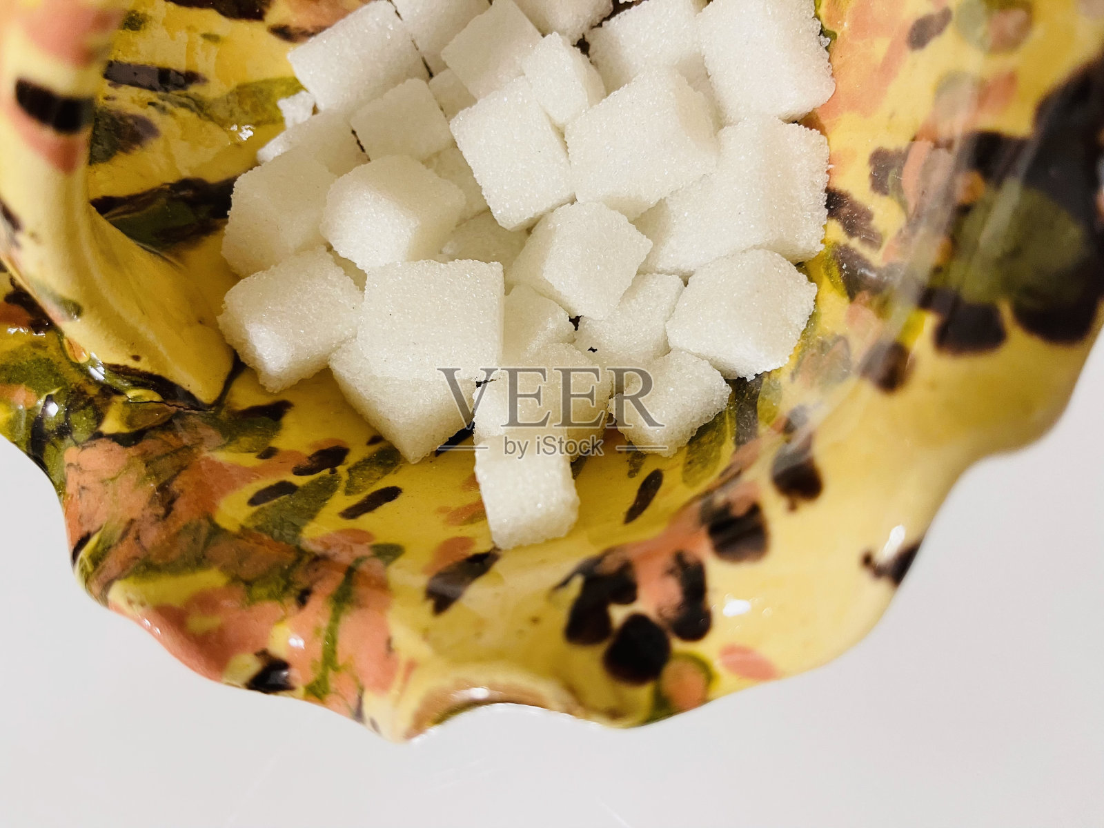 白色背景上的瓷糖碗和许多方糖照片摄影图片