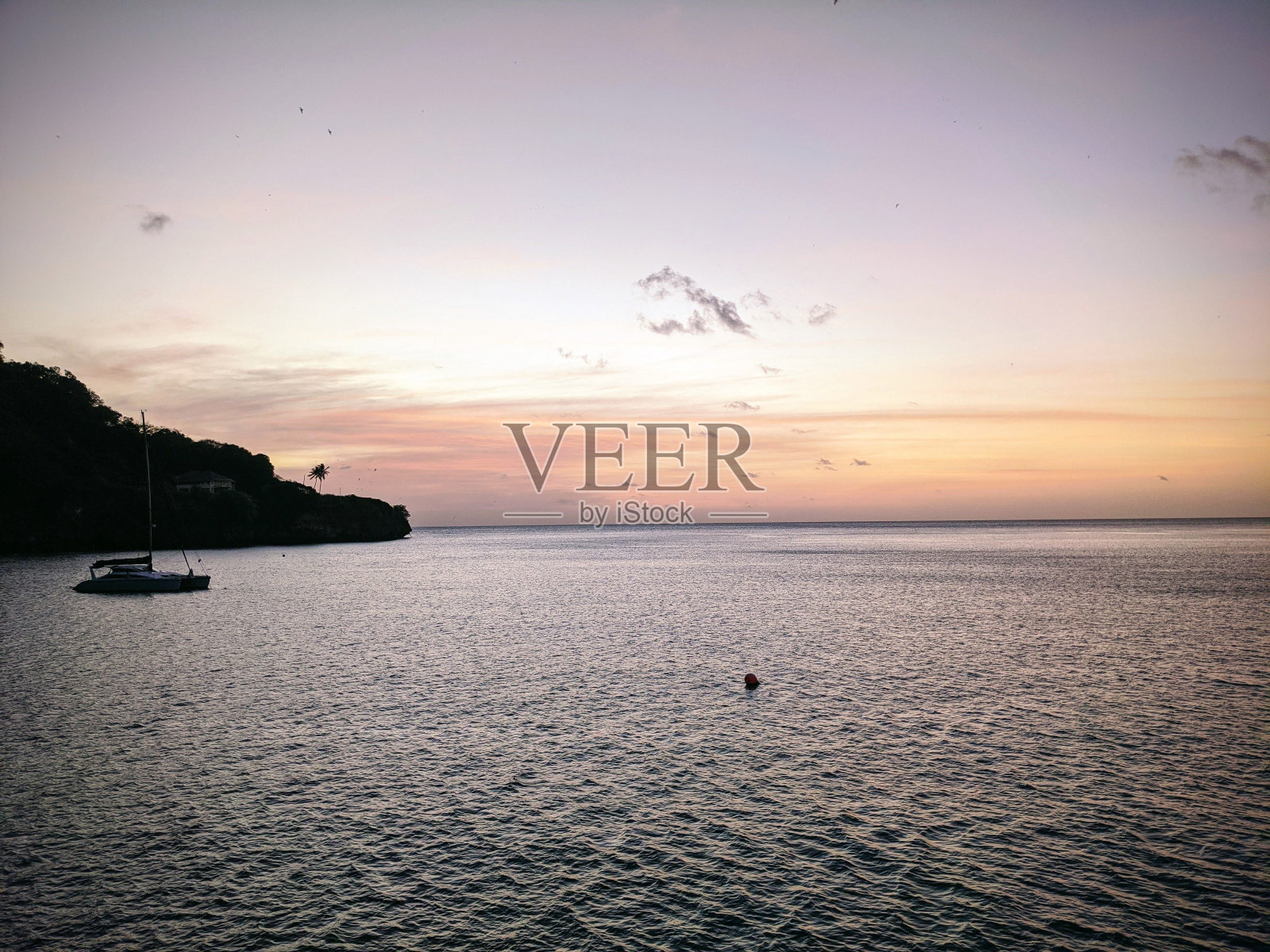 宁静的海滩与沙滩，锯齿状的岩石，在日落清澈的海水照片摄影图片