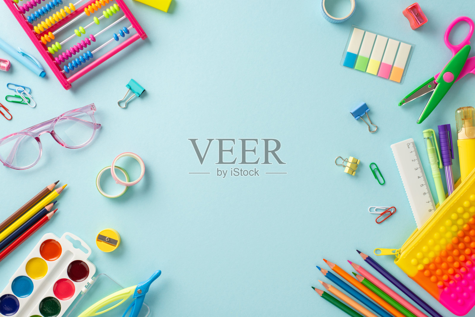 用这种自上而下的视角潜入早期教育的世界:各种明亮的学校用品在宁静的淡蓝色背景下，为文本或广告提供了文案空间照片摄影图片