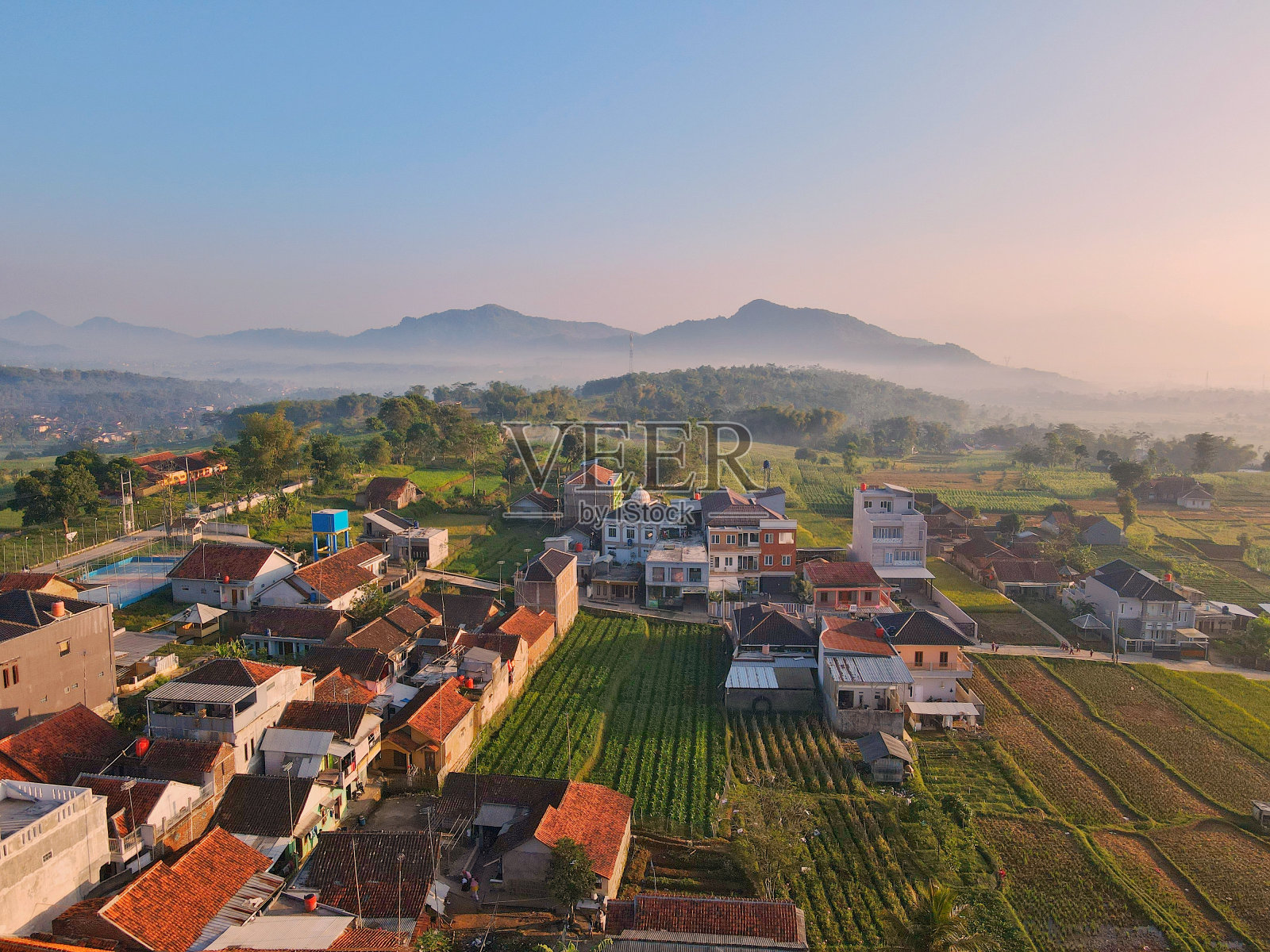 居住在稻田中间，周围环绕着美丽的山景照片摄影图片