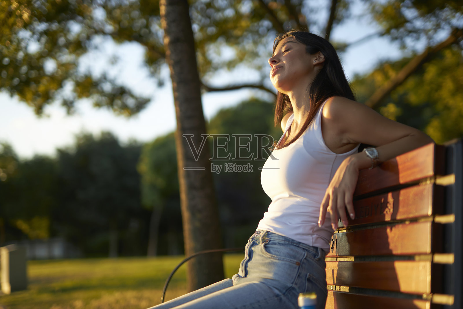 年轻的黑发女郎在公园休息照片摄影图片