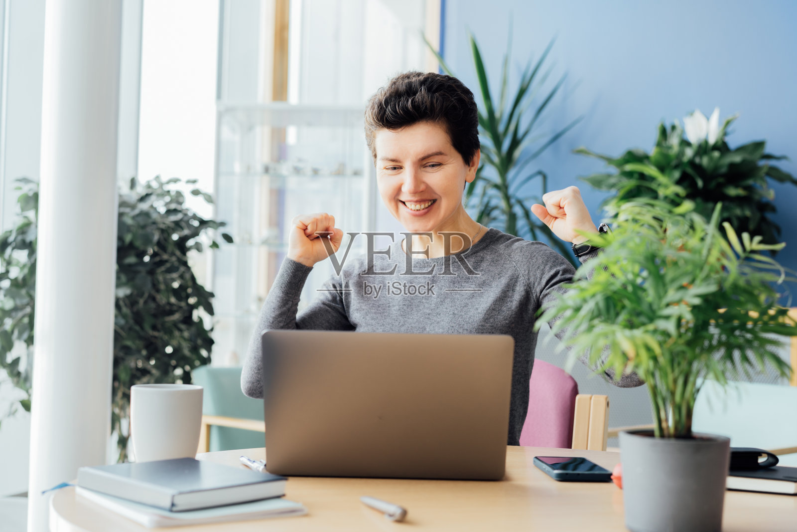 兴奋快乐的中年中性女性感觉赢家在网上赢得了新的工作机会，喜出眉外的女孩做了一个“是”的手势，在pc上收到了庆祝录取的好成绩照片摄影图片