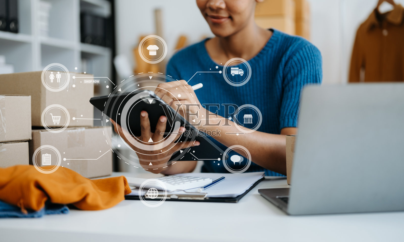 非洲妇女在办公室用手提电脑、智能手机和平板电脑书写笔记本，进行网上购物。在家里用虚拟图标照片摄影图片