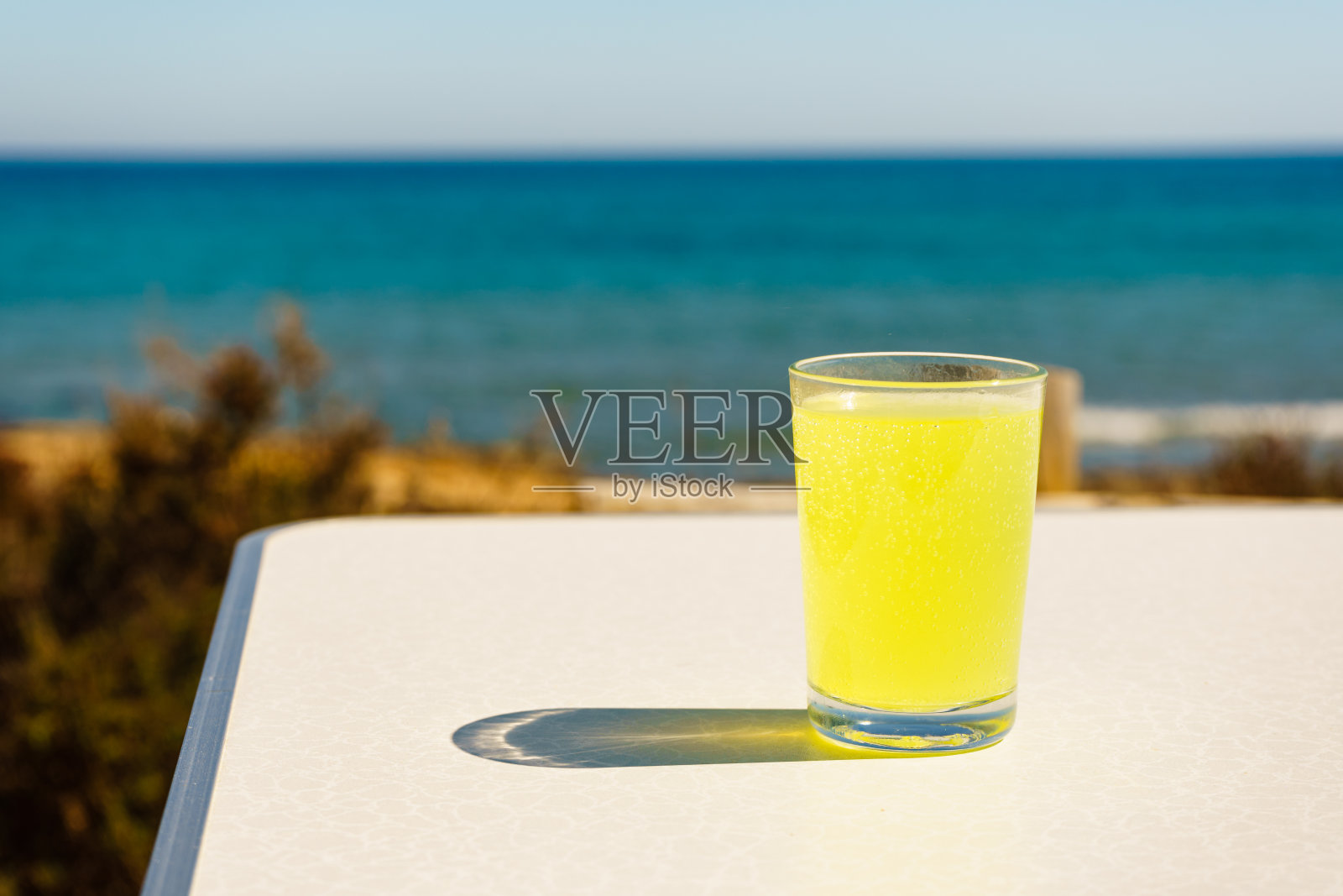 在海边用玻璃杯喝柑橘照片摄影图片