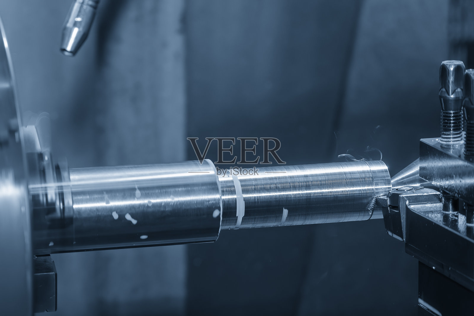 车床精加工金属轴类零件采用液体冷却法。照片摄影图片