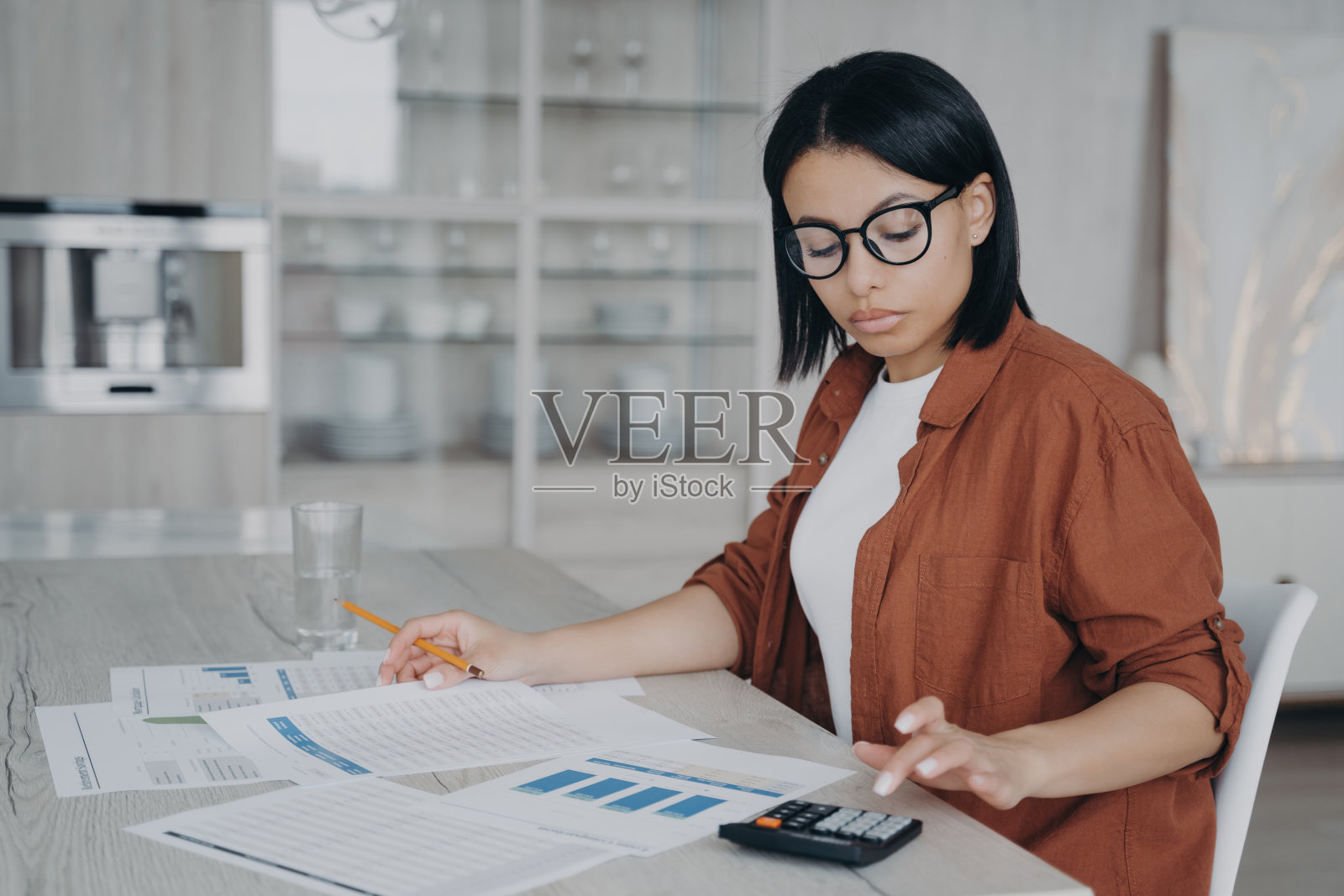 会计审核报告。戴眼镜的商务助理在家处理数据图表。照片摄影图片