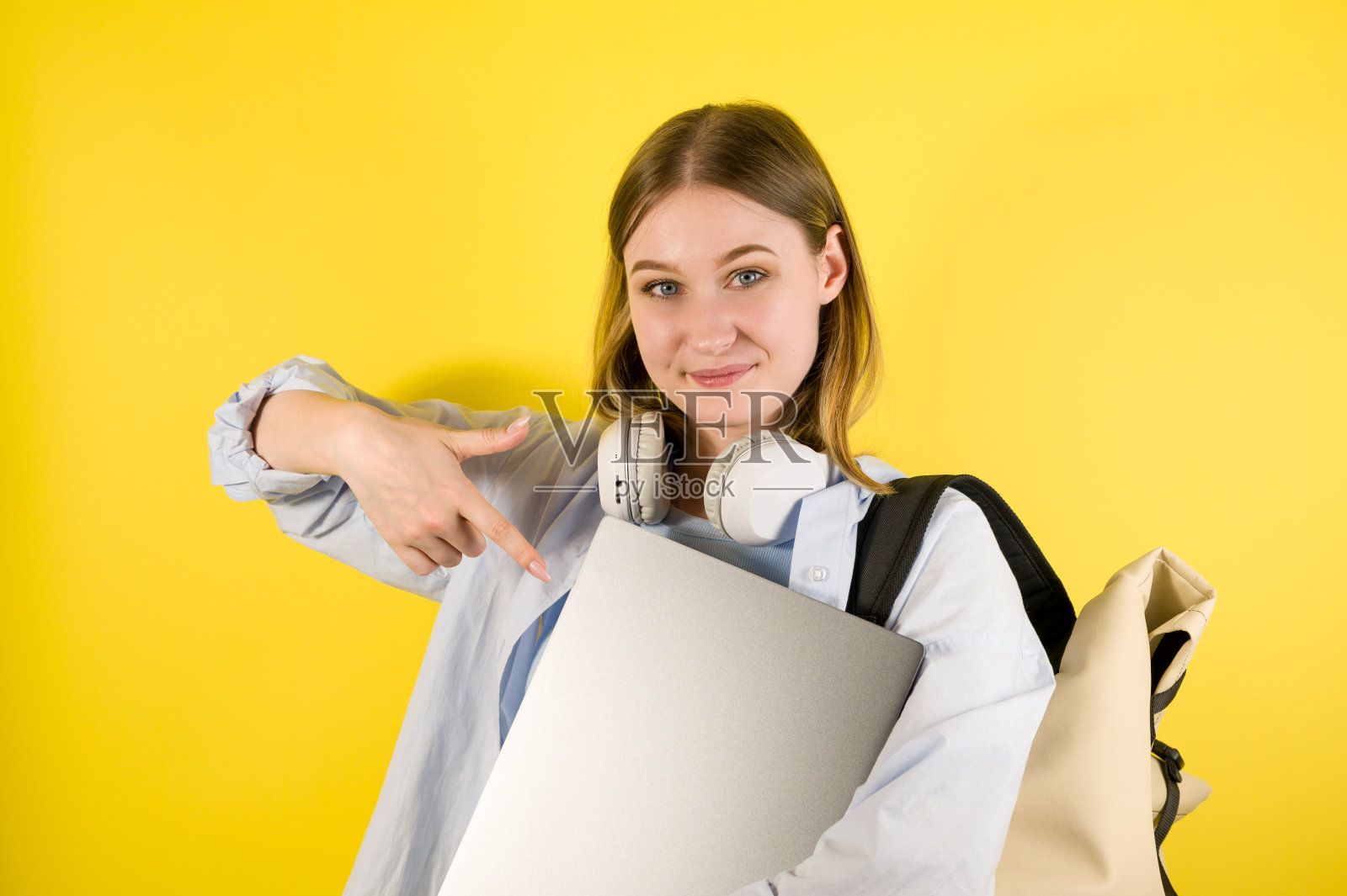 快乐的白人女孩指着笔记本电脑。在线教育或销售笔记本电脑照片摄影图片