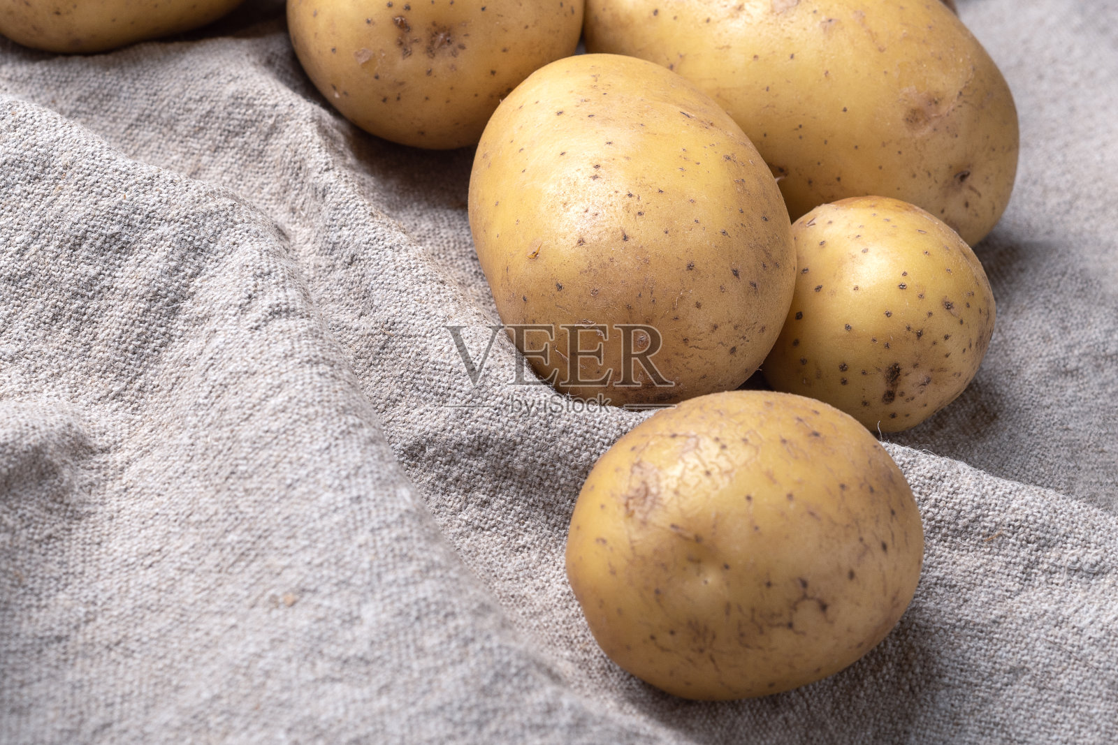 粗麻布上的几个土豆块茎。照片摄影图片
