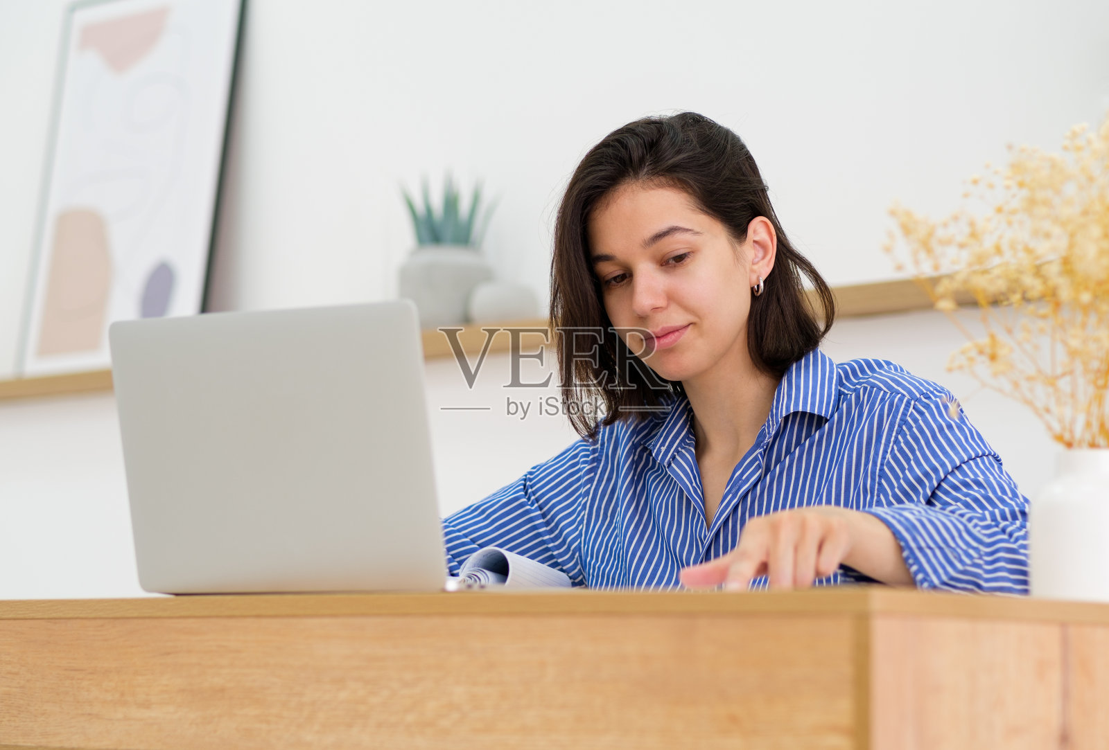 漂亮的少女戴着耳机，用笔记本电脑在线学习科目，提高外语技能，获得新知识。学费，与导师的视频通话活动，帮助锻炼。学费，现代科技照片摄影图片