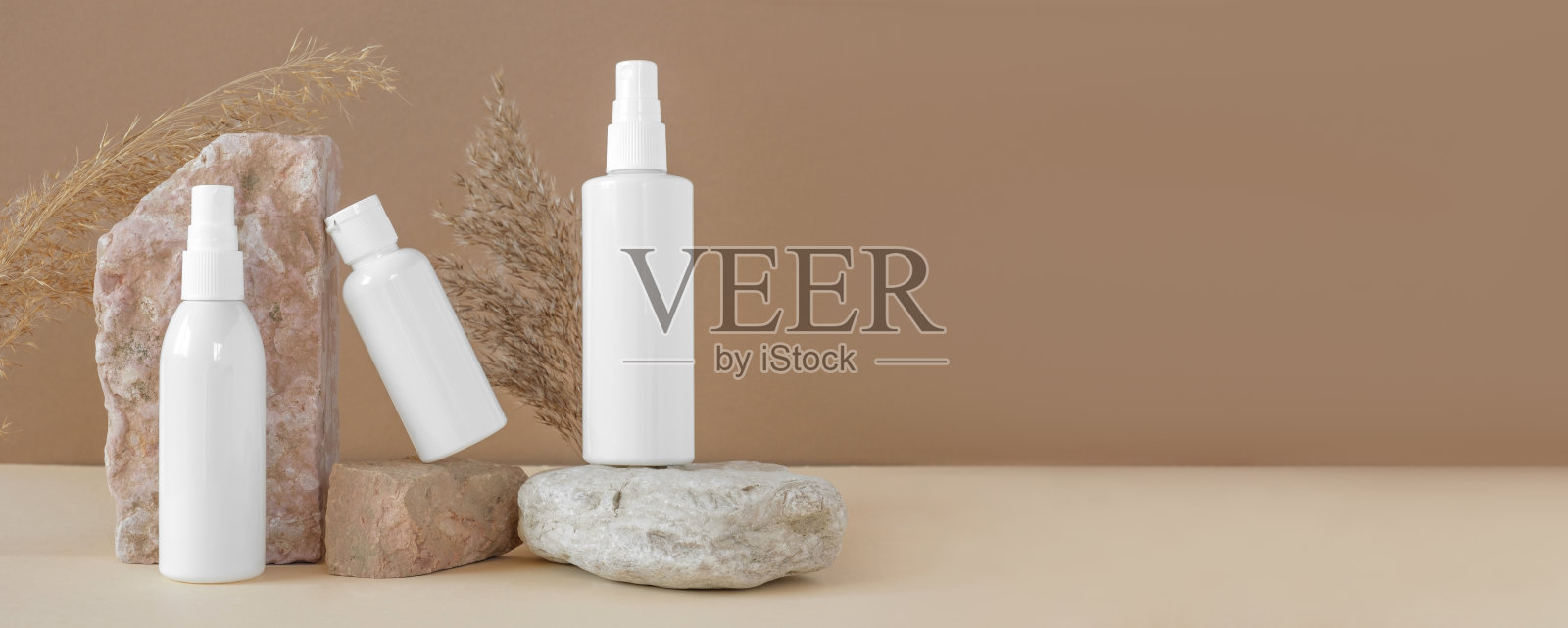 白色空白化妆瓶，石质平台上的干草药。天然护肤SPA美容产品设计。矿物有机化妆品模型。米色背景。面部和身体治疗。前视图。照片摄影图片