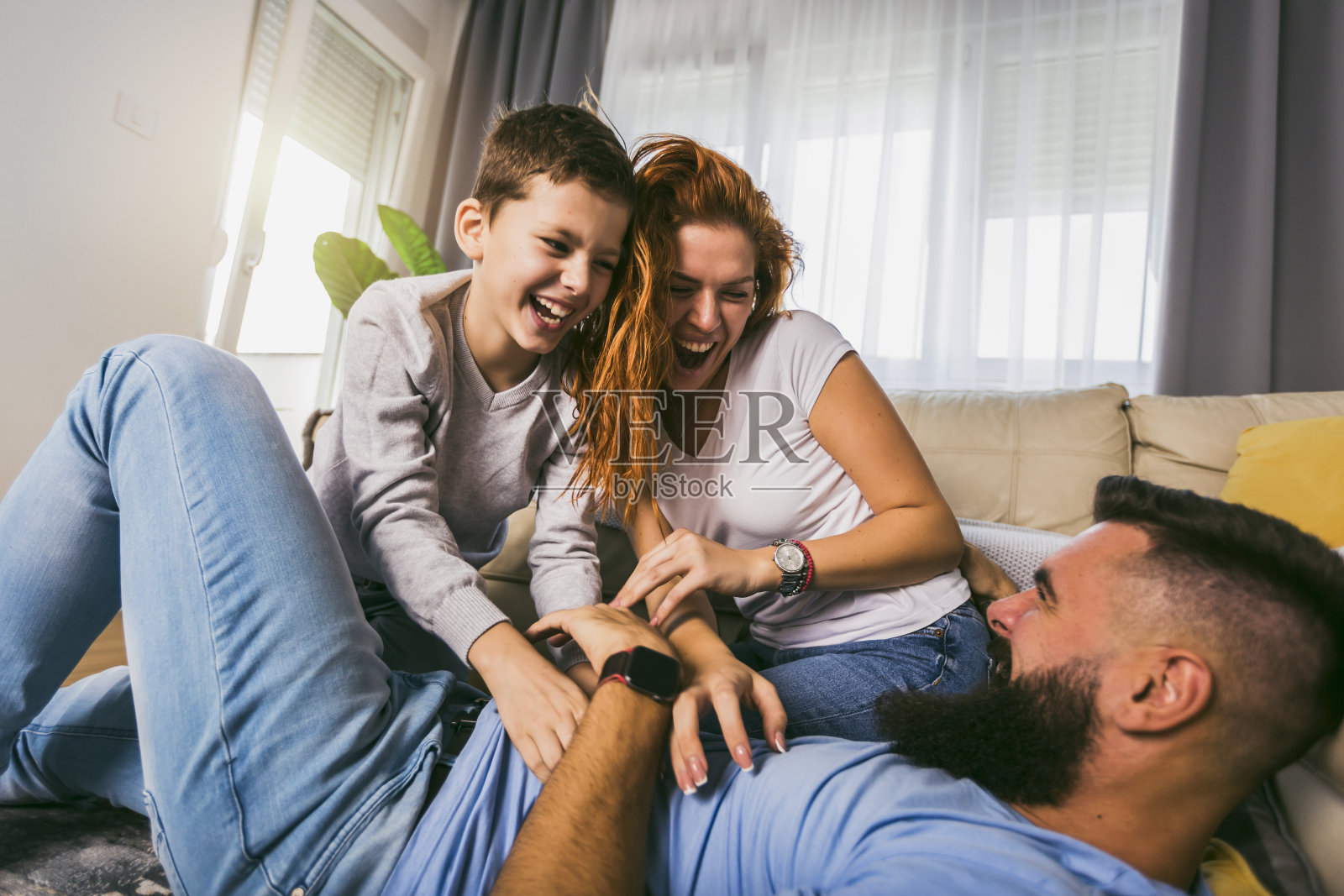 年轻的家庭和他们的儿子在家里玩照片摄影图片