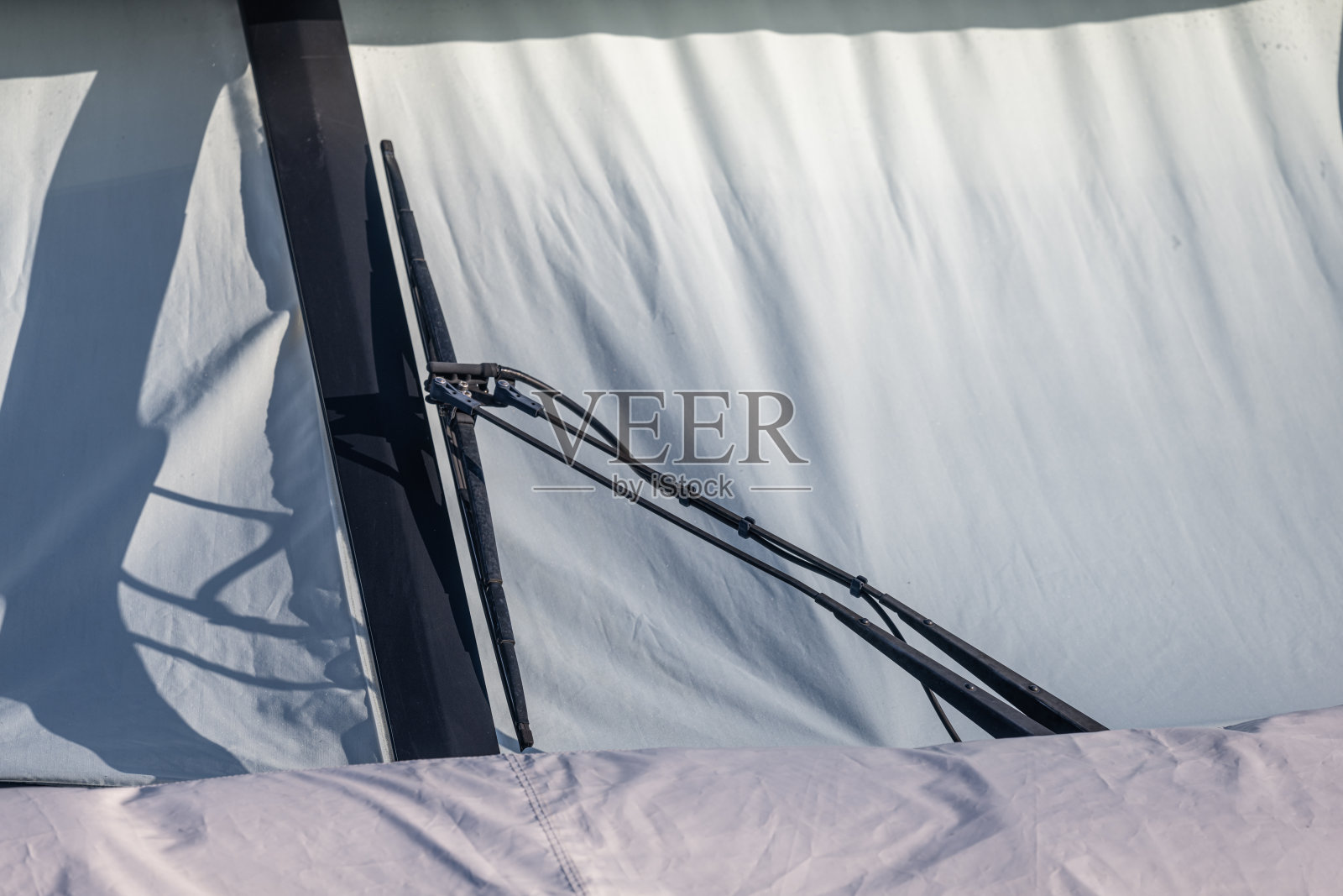 装有白布窗罩的客舱巡洋舰的挡风玻璃雨刷器。照片摄影图片