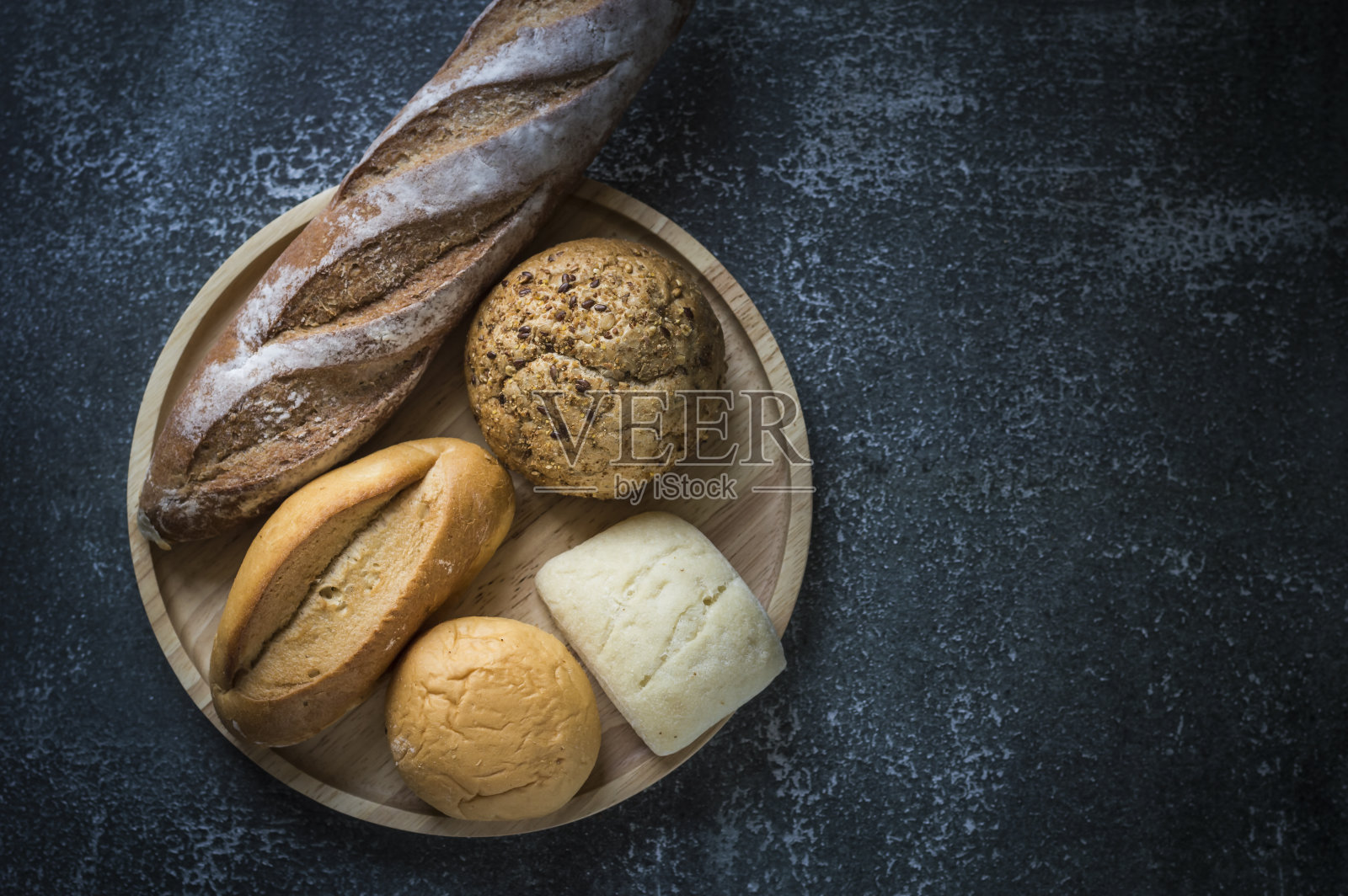 木盘上刚烤好的面包。前视图。照片摄影图片