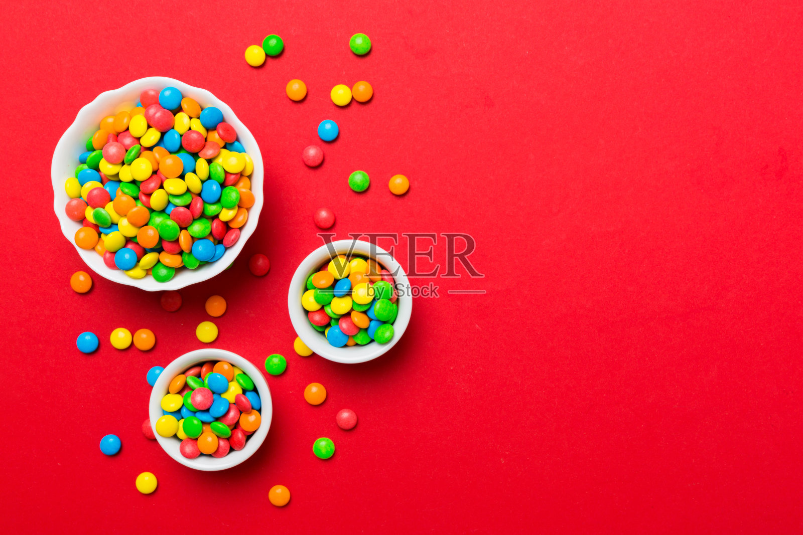 不同颜色的圆形糖果放在碗和罐子里。大品种的糖果和糖果的俯视图与复制空间照片摄影图片