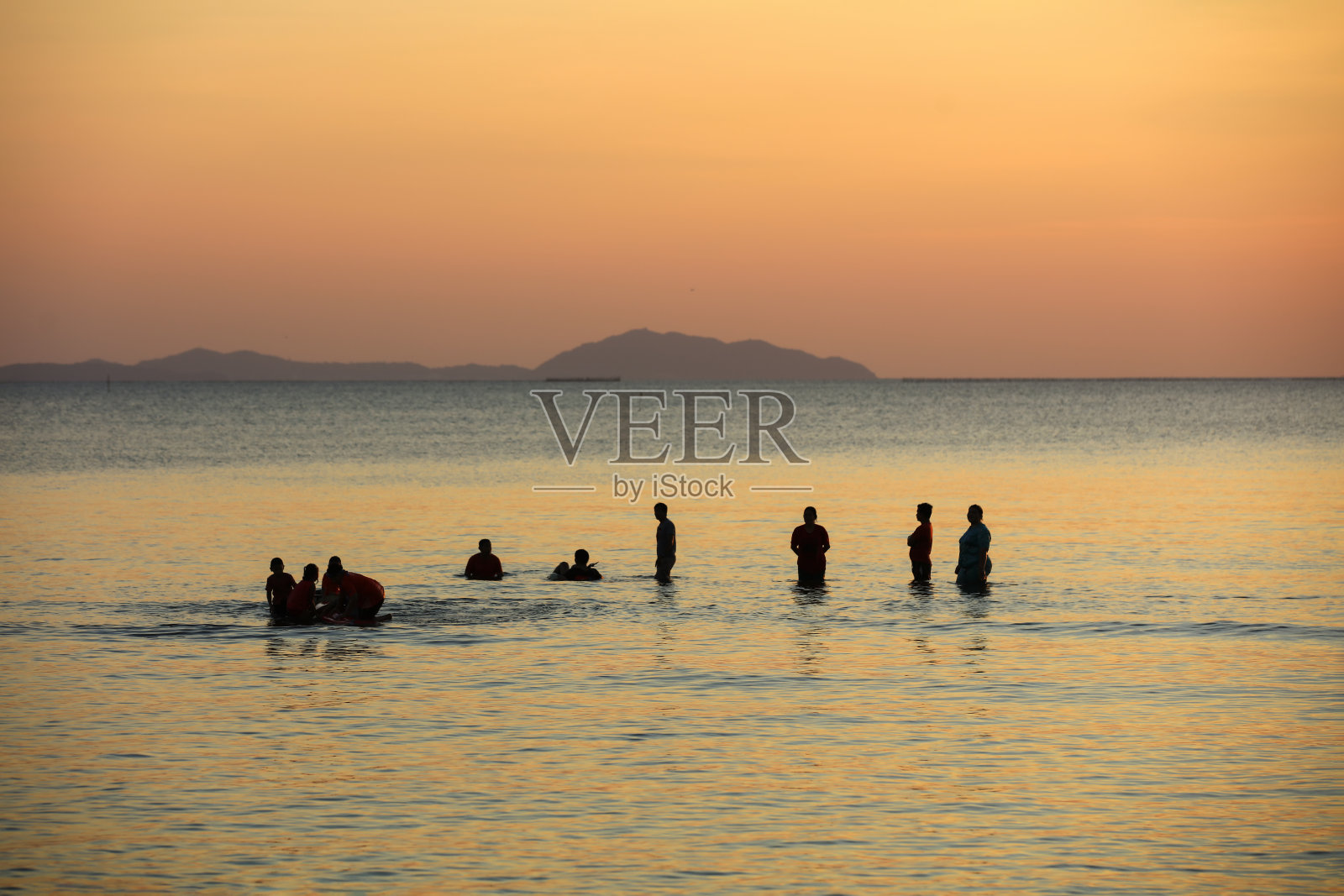 暑假户外，成群结队的游客在海里玩水。照片摄影图片